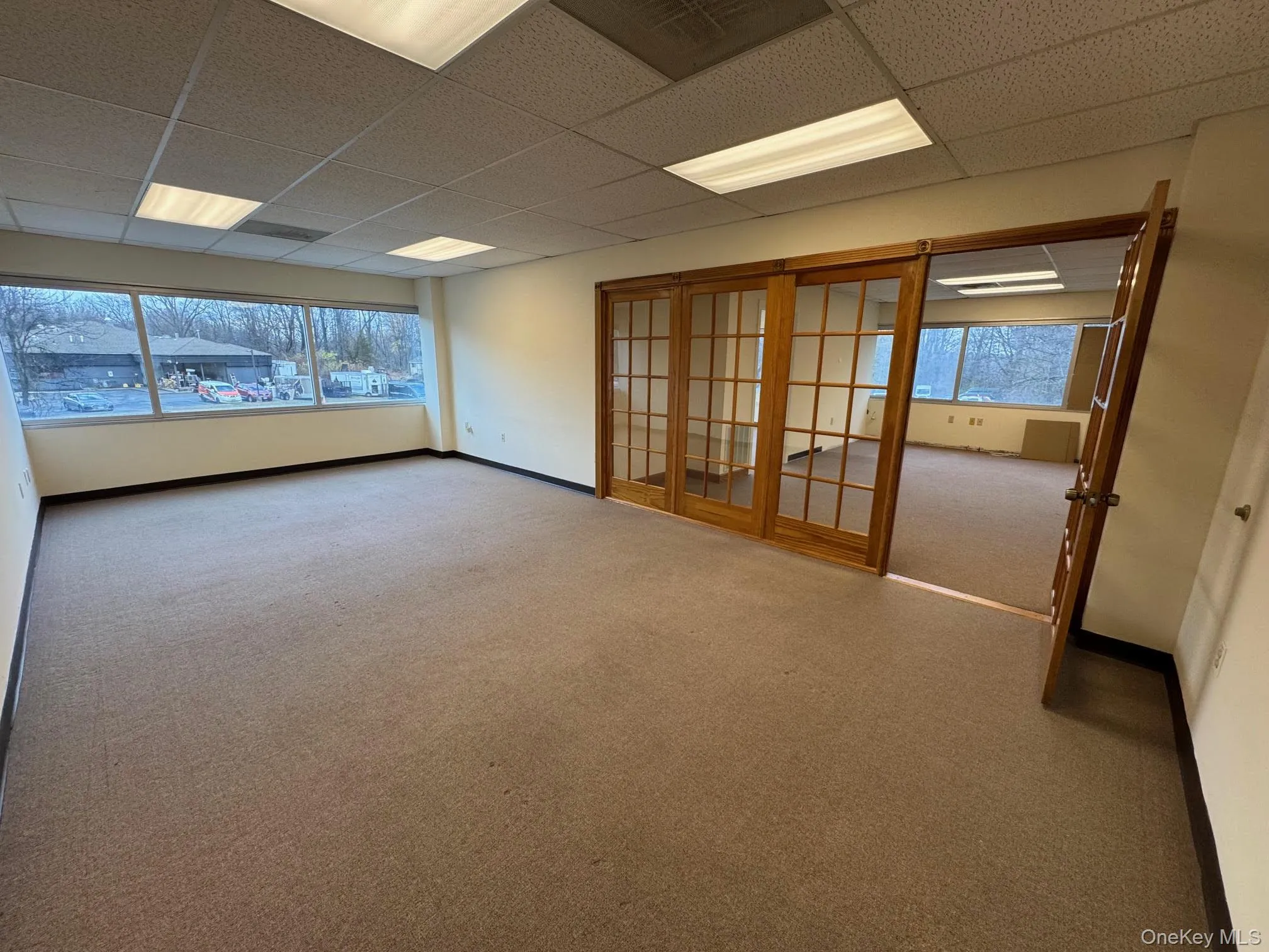 Carpeted empty room featuring a paneled ceiling Carpeted empty room featuring a paneled ceiling