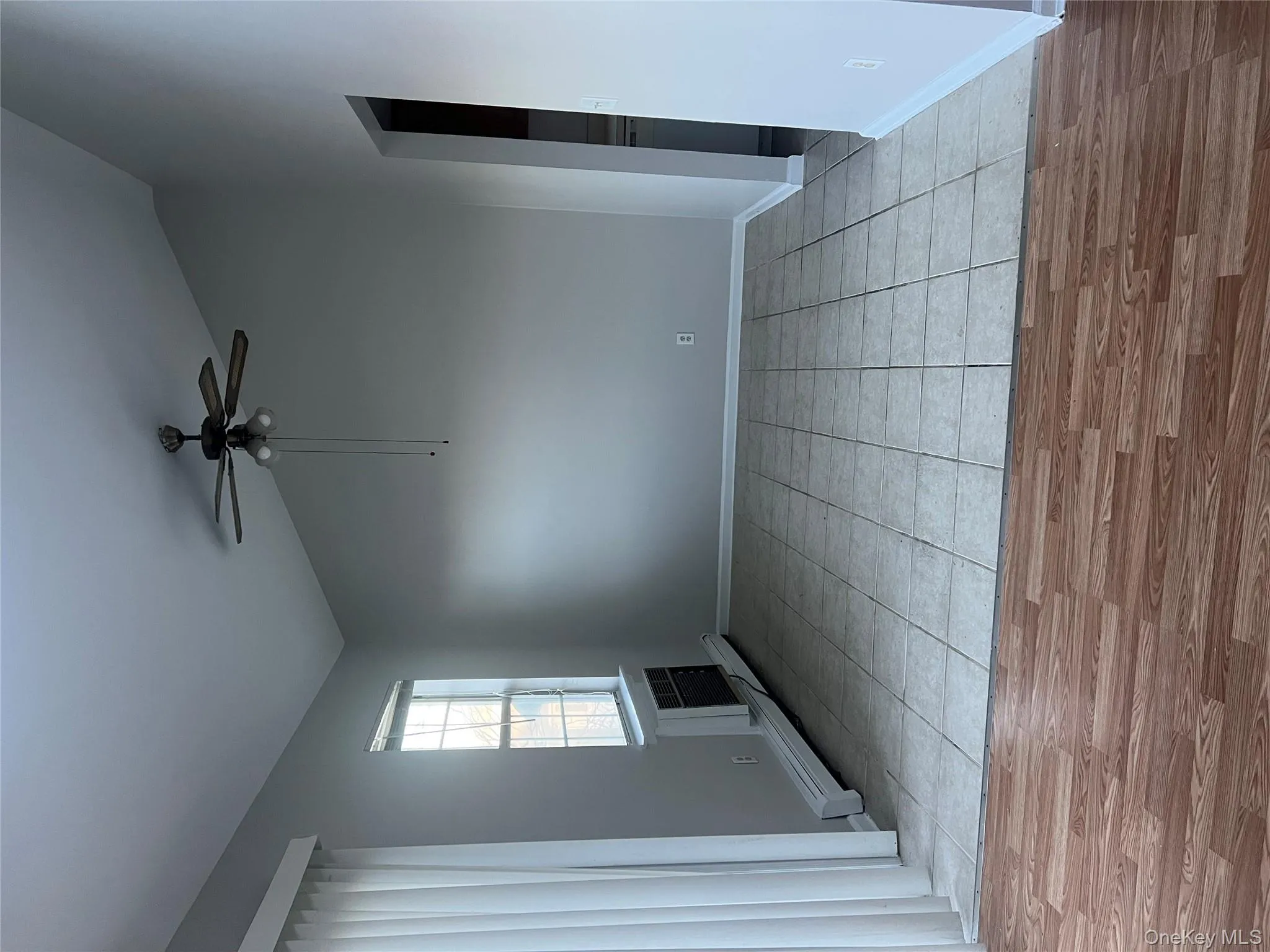 Spare room with lofted ceiling, a baseboard radiator, a ceiling fan, and light wood-style floors Spare room with lofted ceiling, a baseboard radiator, a ceiling fan, and light wood-style floors