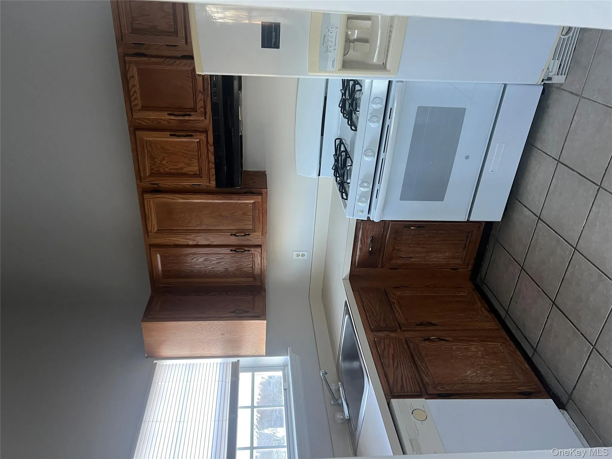 Kitchen featuring white range oven, light countertops, refrigerator, dishwasher, and ventilation hood Kitchen featuring white range oven, light countertops, refrigerator, dishwasher, and ventilation hood