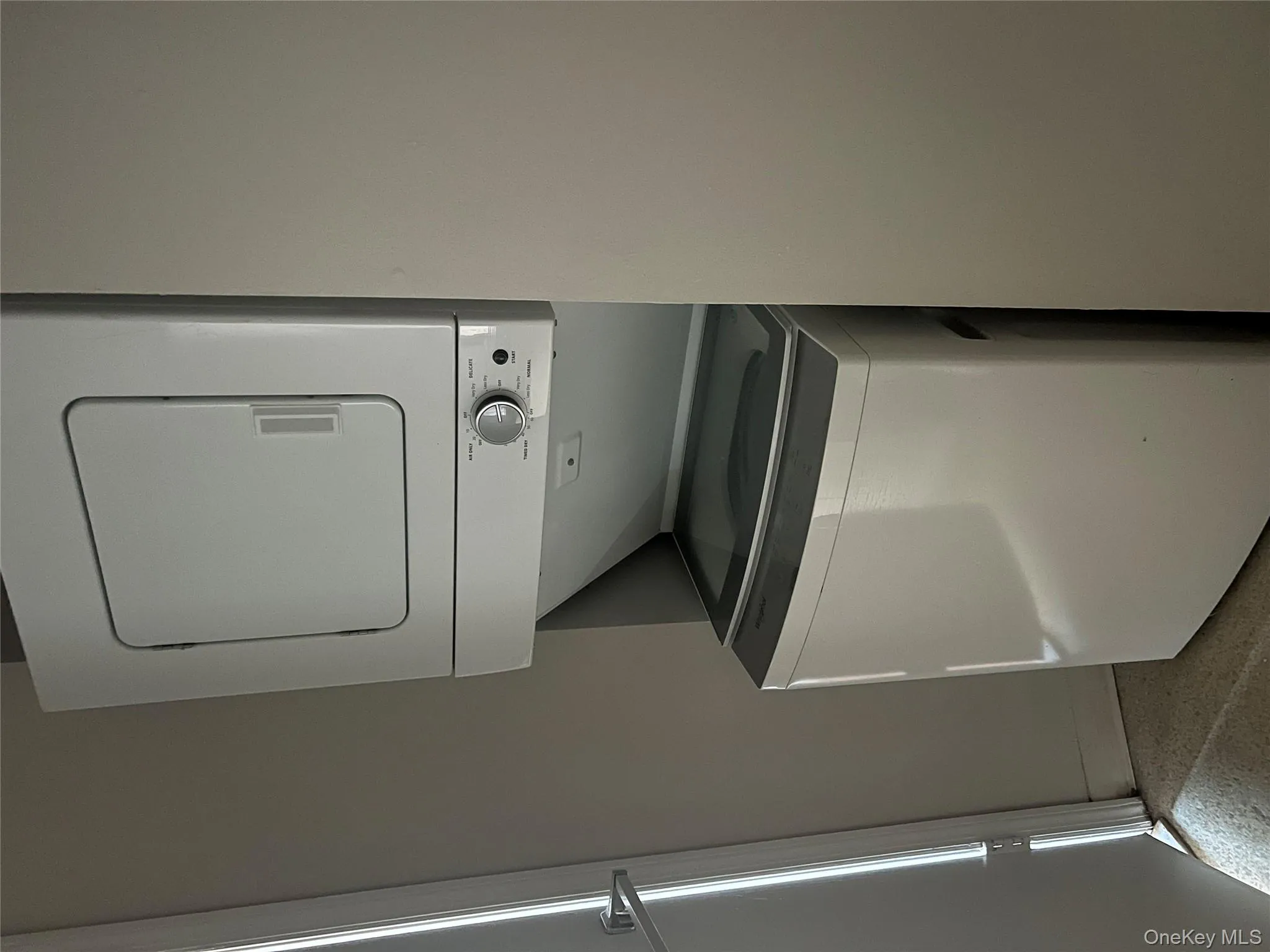 Washroom featuring stacked washer / drying machine Washroom featuring stacked washer / drying machine