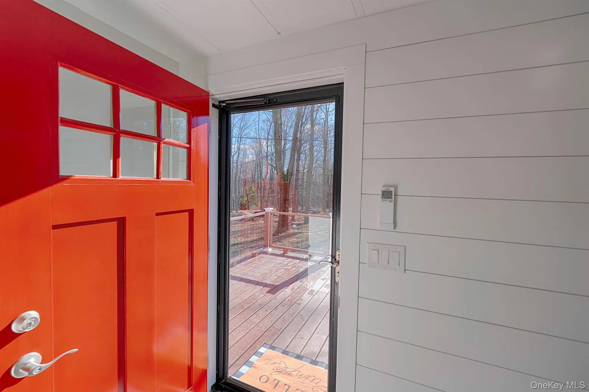 Doorway with plenty of natural light, wood walls, and wood finished floors Doorway with plenty of natural light, wood walls, and wood finished floors
