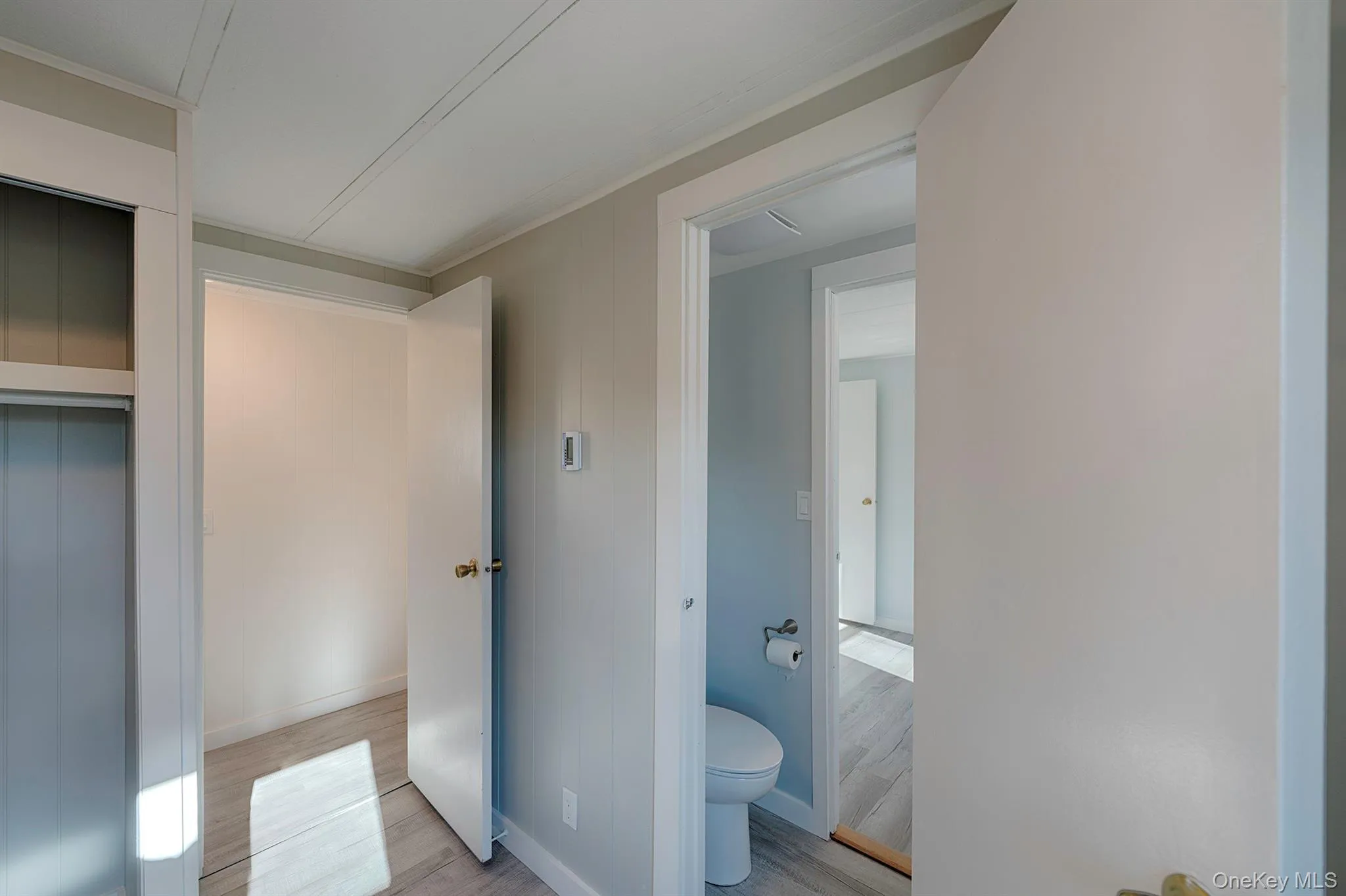 Half bathroom with light wood-style flooring and elevator Half bathroom with light wood-style flooring and elevator