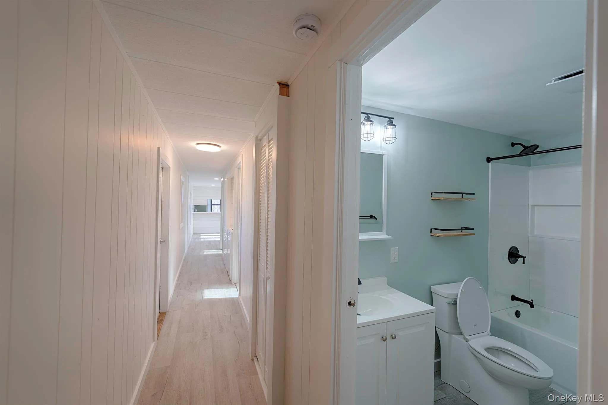 Full bathroom featuring vanity, bathtub / shower combination, and light wood-style flooring Full bathroom featuring vanity, bathtub / shower combination, and light wood-style flooring
