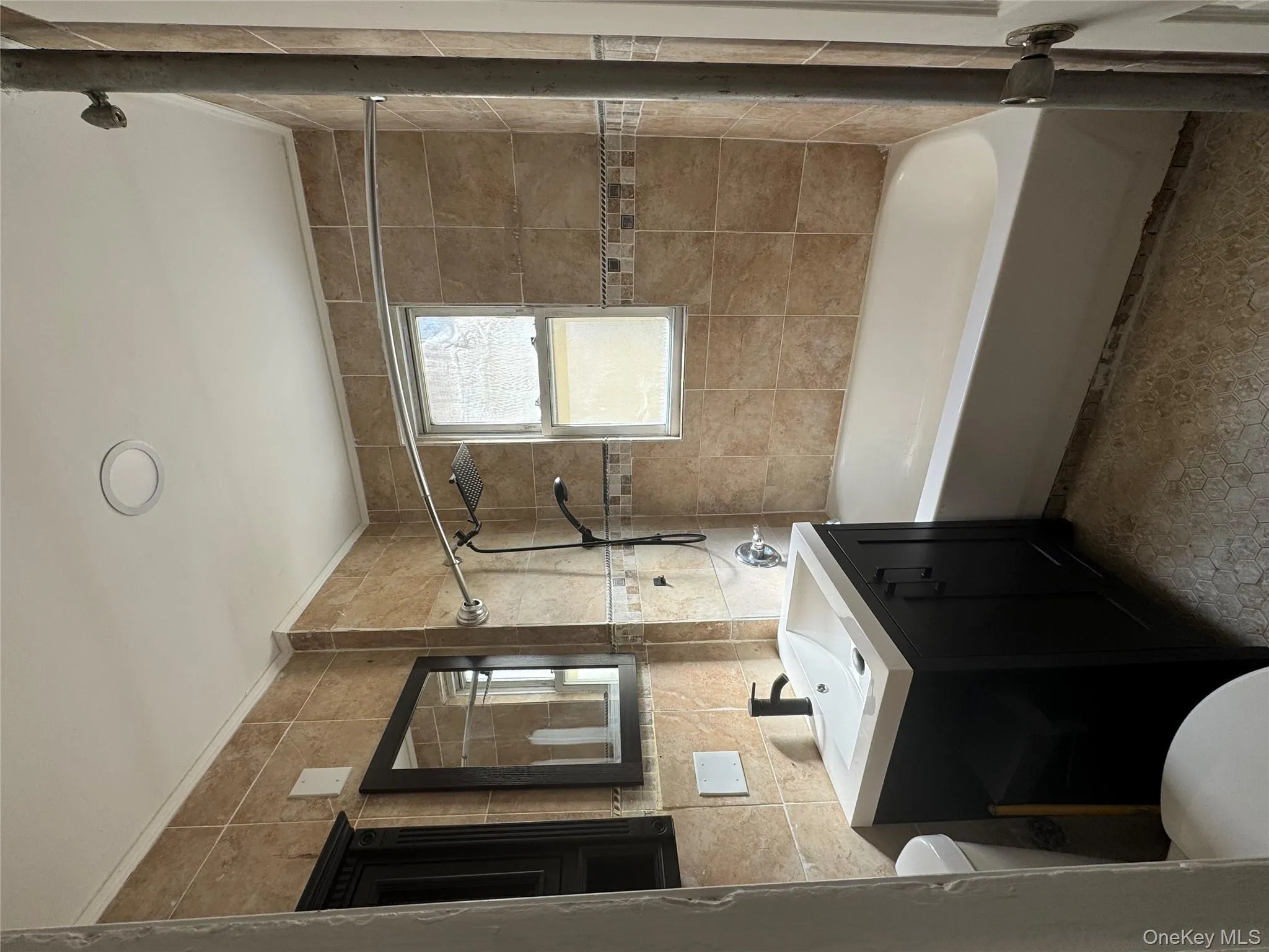 Bathroom featuring vanity, tile walls, and shower / washtub combination Bathroom featuring vanity, tile walls, and shower / washtub combination
