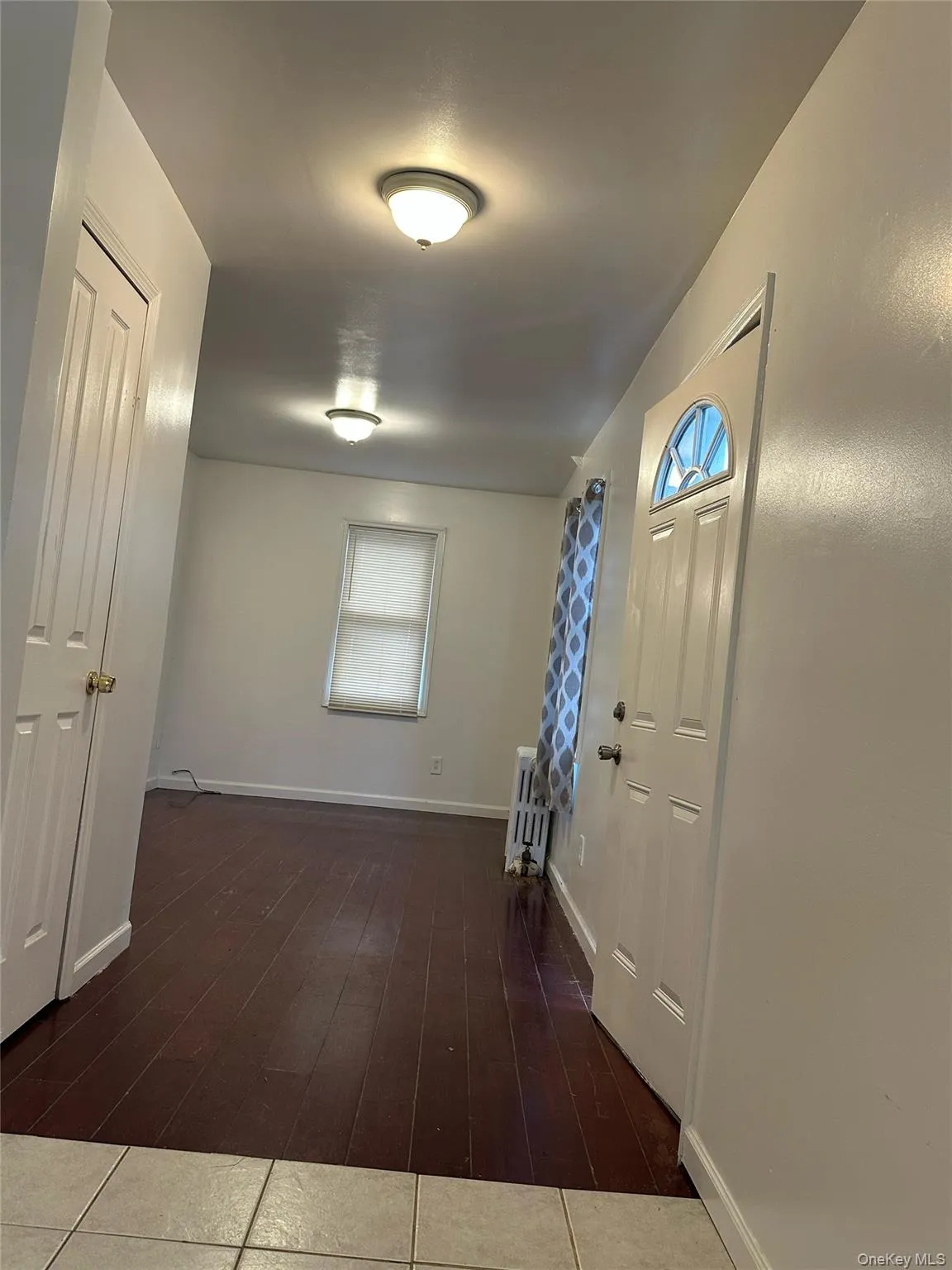 Corridor with radiator heating unit and dark wood-style floors Corridor with radiator heating unit and dark wood-style floors