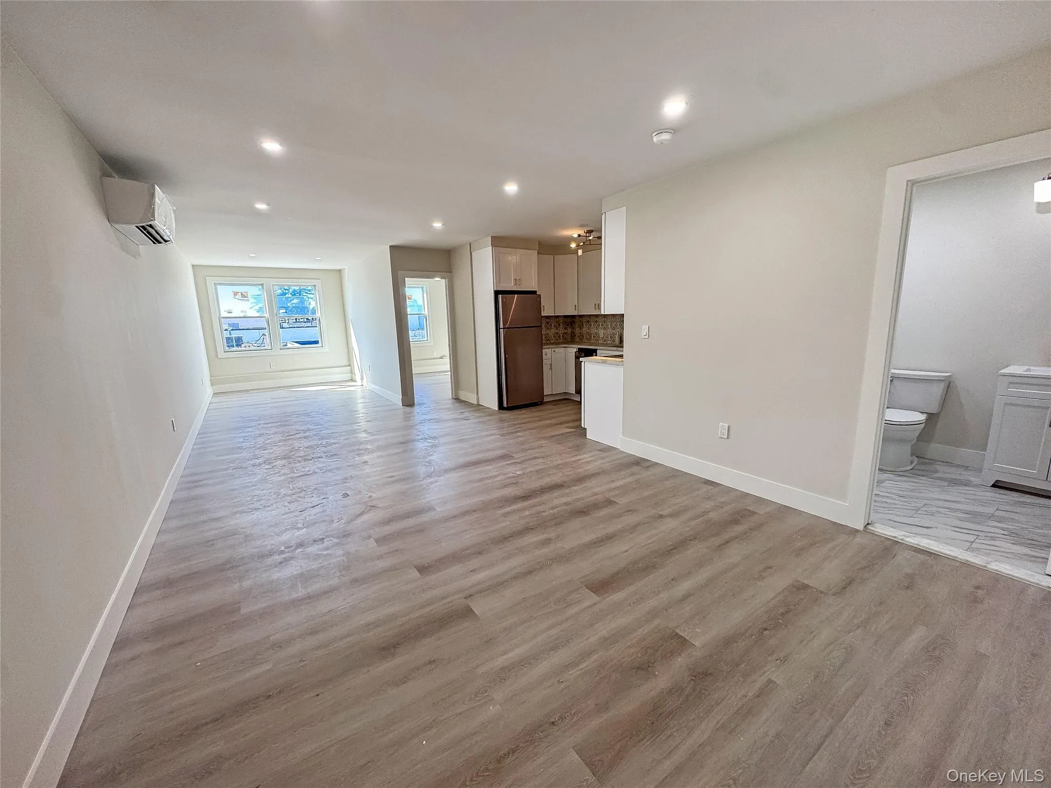 Unfurnished living room with light wood-style flooring and recessed lighting Unfurnished living room with light wood-style flooring and recessed lighting