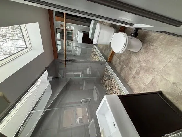 Bathroom with vanity, a stall shower, a skylight, and lofted ceiling Bathroom with vanity, a stall shower, a skylight, and lofted ceiling