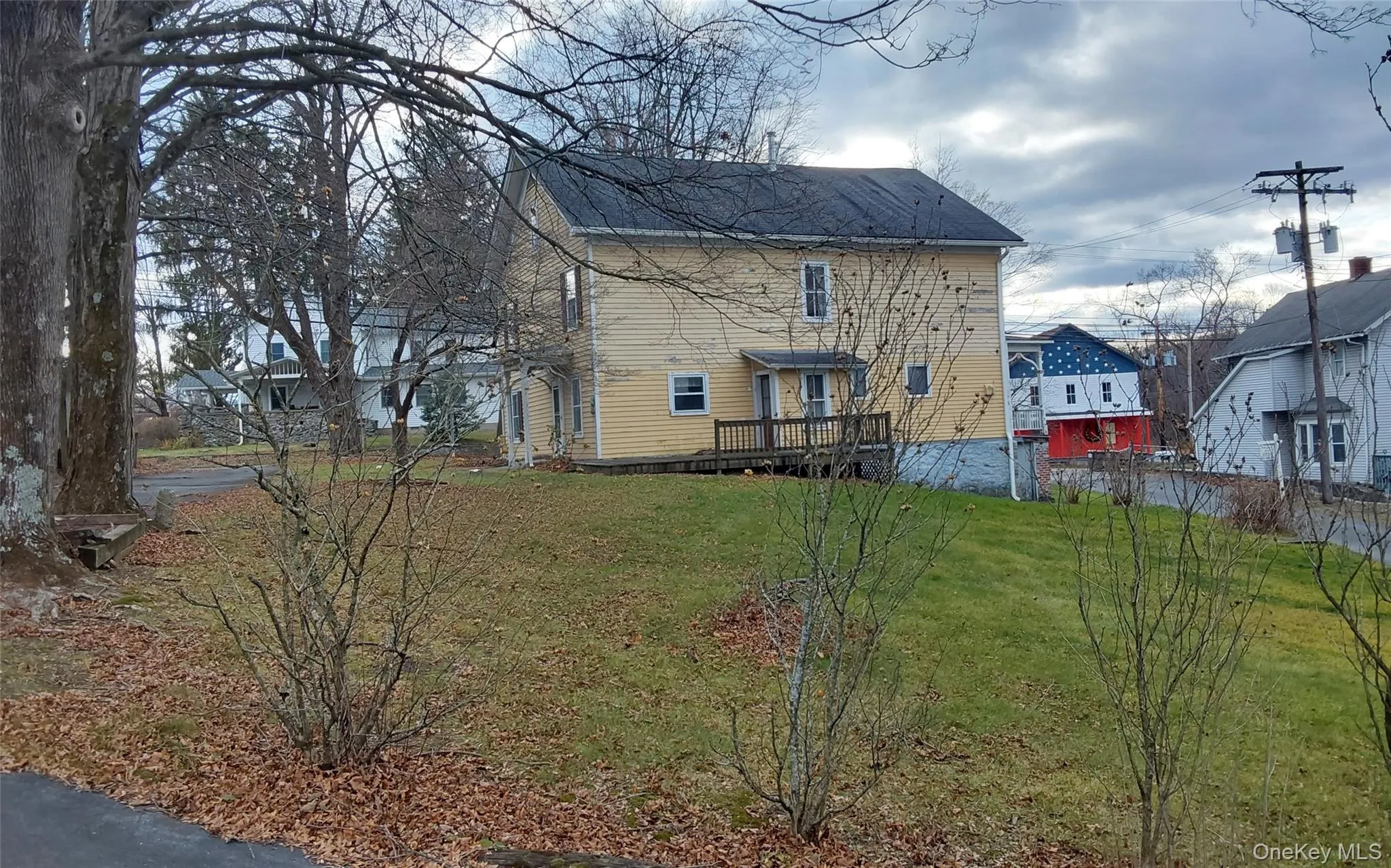 View of home's exterior featuring a lawn, a deck, and a residential view View of home's exterior featuring a lawn, a deck, and a residential view
