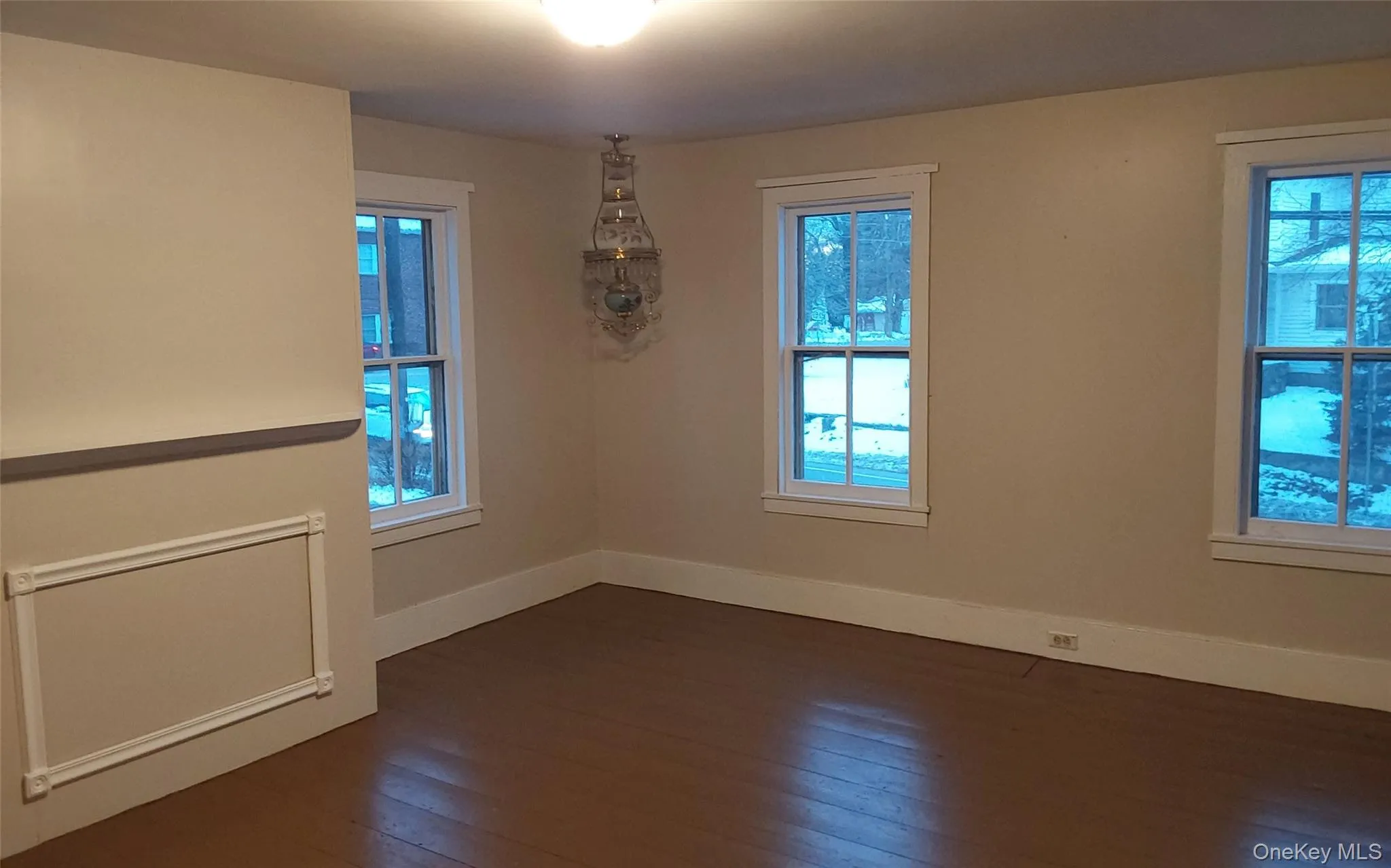 Empty room with dark wood finished floors and healthy amount of natural light Empty room with dark wood finished floors and healthy amount of natural light