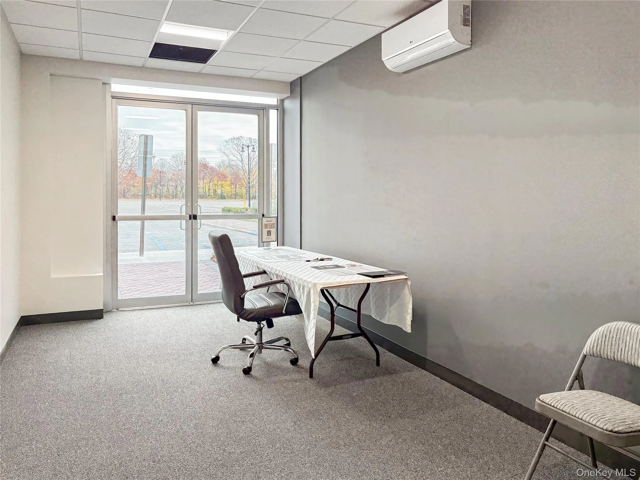 Home office featuring a drop ceiling and an AC wall unit Home office featuring a drop ceiling and an AC wall unit