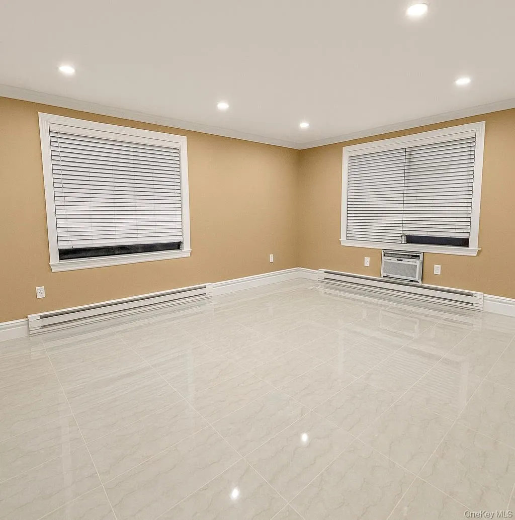 Spare room featuring a baseboard radiator, recessed lighting, a wall unit AC, and ornamental molding Spare room featuring a baseboard radiator, recessed lighting, a wall unit AC, and ornamental molding