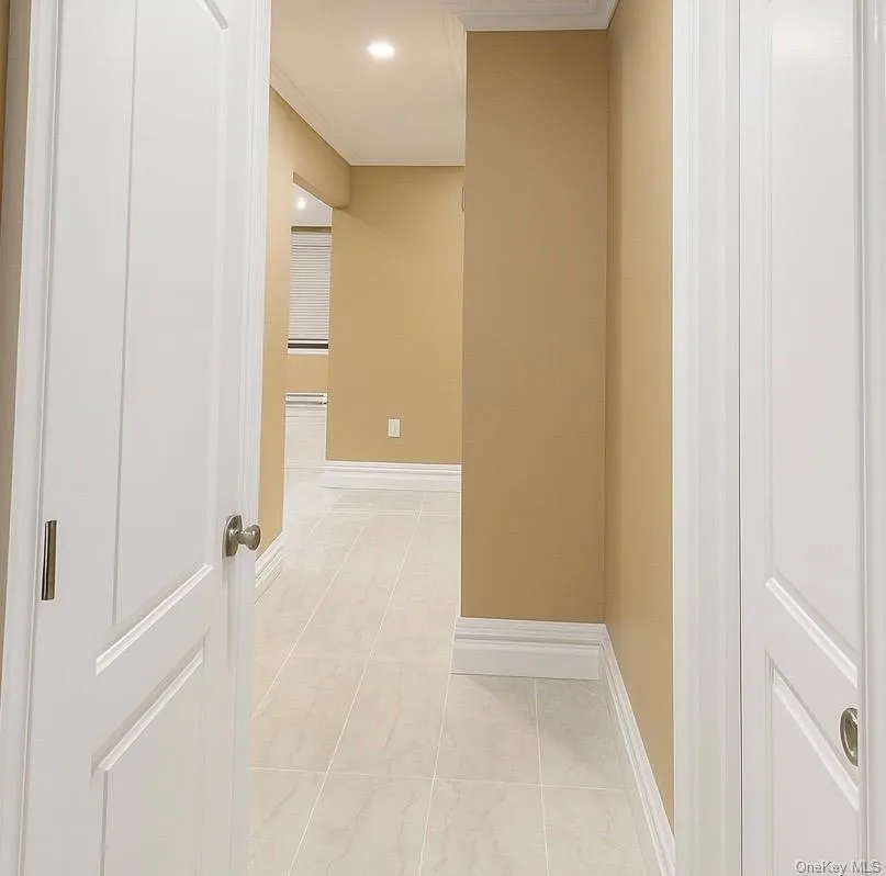 Corridor featuring crown molding, recessed lighting, and light tile patterned flooring Corridor featuring crown molding, recessed lighting, and light tile patterned flooring