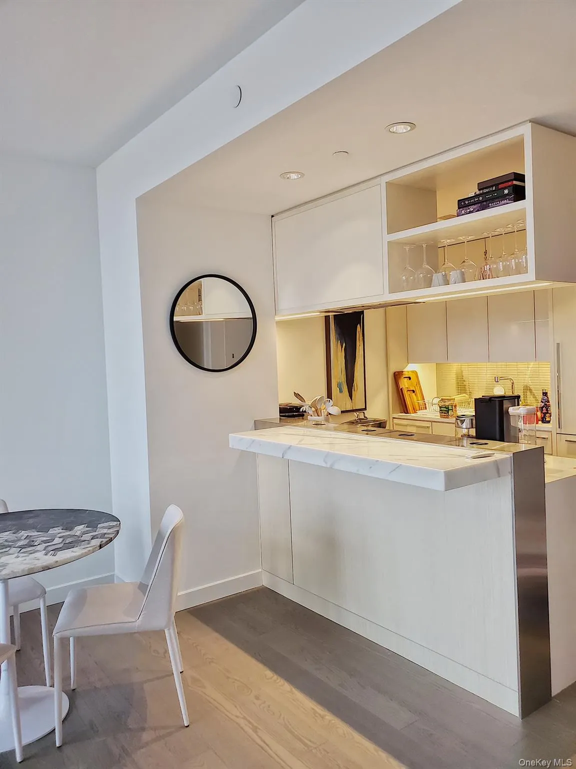 Kitchen featuring light countertops, wood finished floors, tasteful backsplash, a kitchen breakfast bar, and a peninsula Kitchen featuring light countertops, wood finished floors, tasteful backsplash, a kitchen breakfast bar, and a peninsula