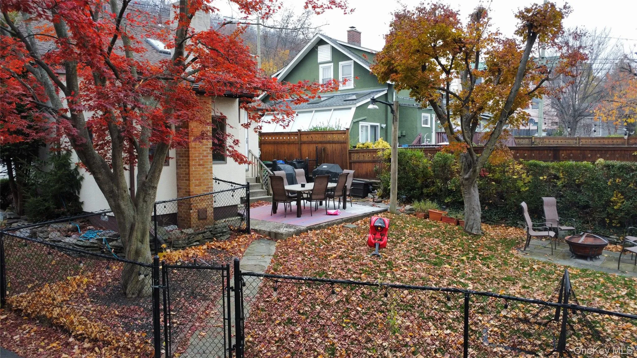 Fenced backyard featuring a patio, a fire pit, and a gate Fenced backyard featuring a patio, a fire pit, and a gate