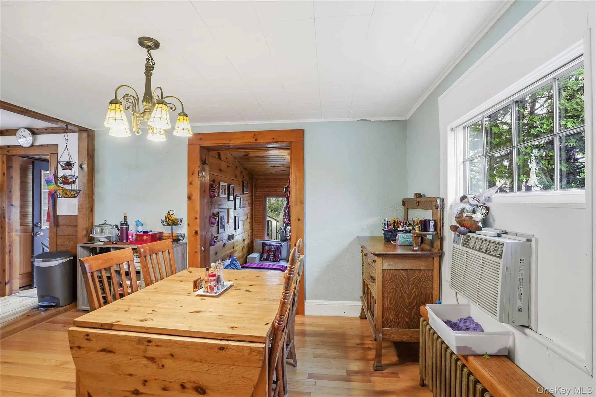 Dining space featuring light wood-style flooring, a chandelier, and cooling unit Dining space featuring light wood-style flooring, a chandelier, and cooling unit
