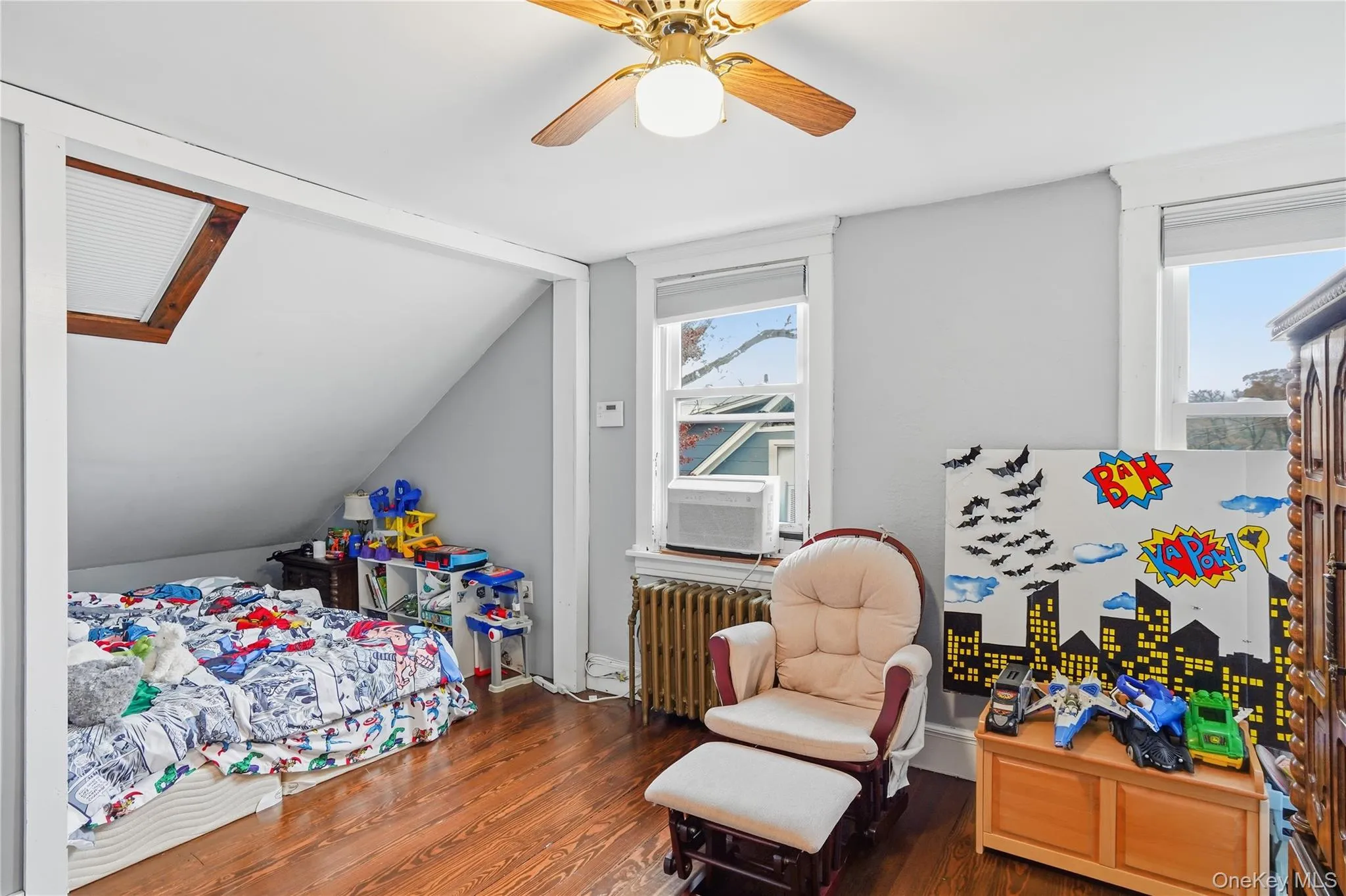Bedroom featuring radiator heating unit, dark wood finished floors, a ceiling fan, lofted ceiling, and cooling unit Bedroom featuring radiator heating unit, dark wood finished floors, a ceiling fan, lofted ceiling, and cooling unit