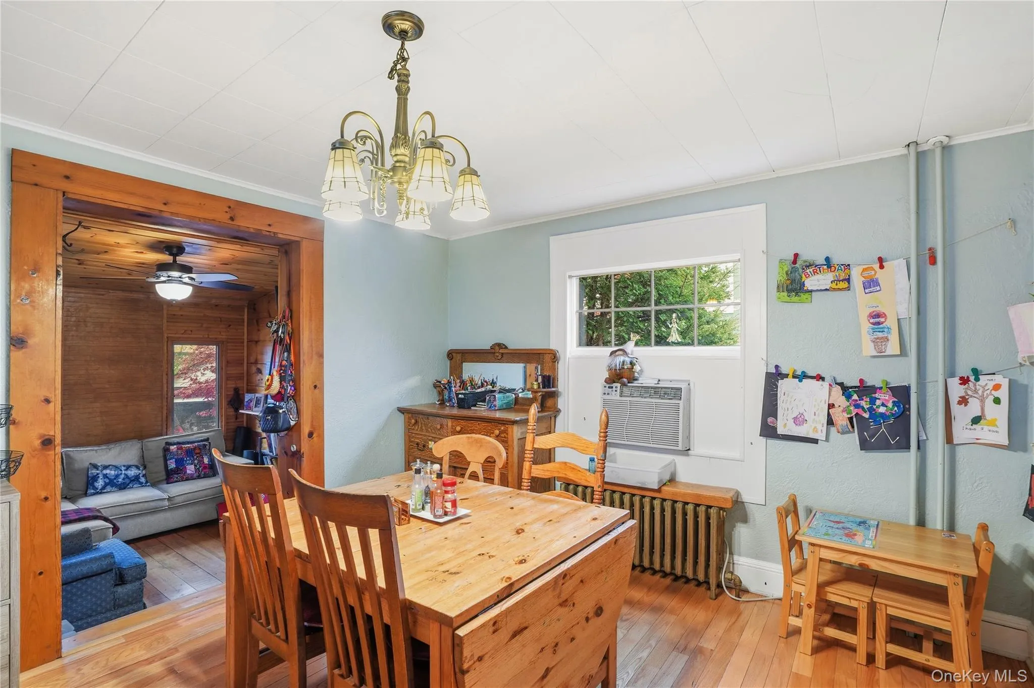 Dining room with hardwood / wood-style flooring, a chandelier, crown molding, radiator heating unit, and a ceiling fan Dining room with hardwood / wood-style flooring, a chandelier, crown molding, radiator heating unit, and a ceiling fan