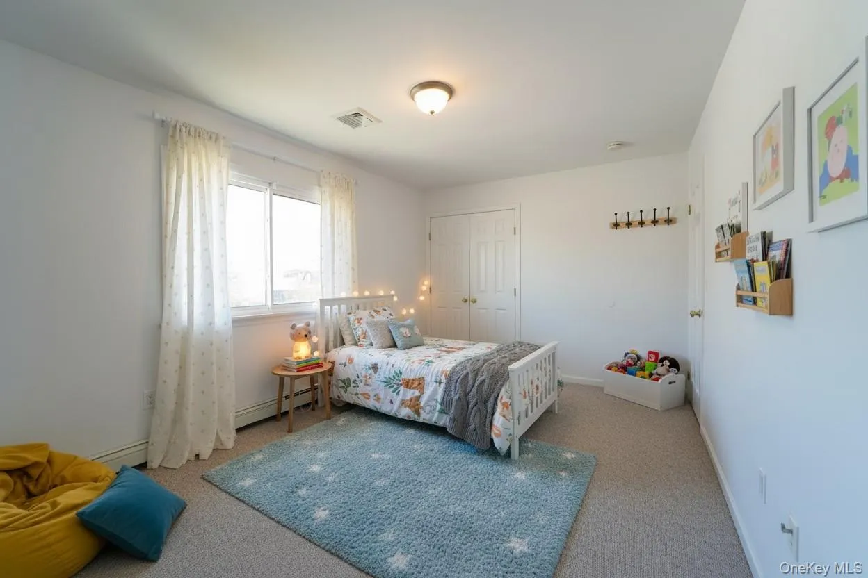 Carpeted bedroom featuring a closet and baseboard heating Carpeted bedroom featuring a closet and baseboard heating