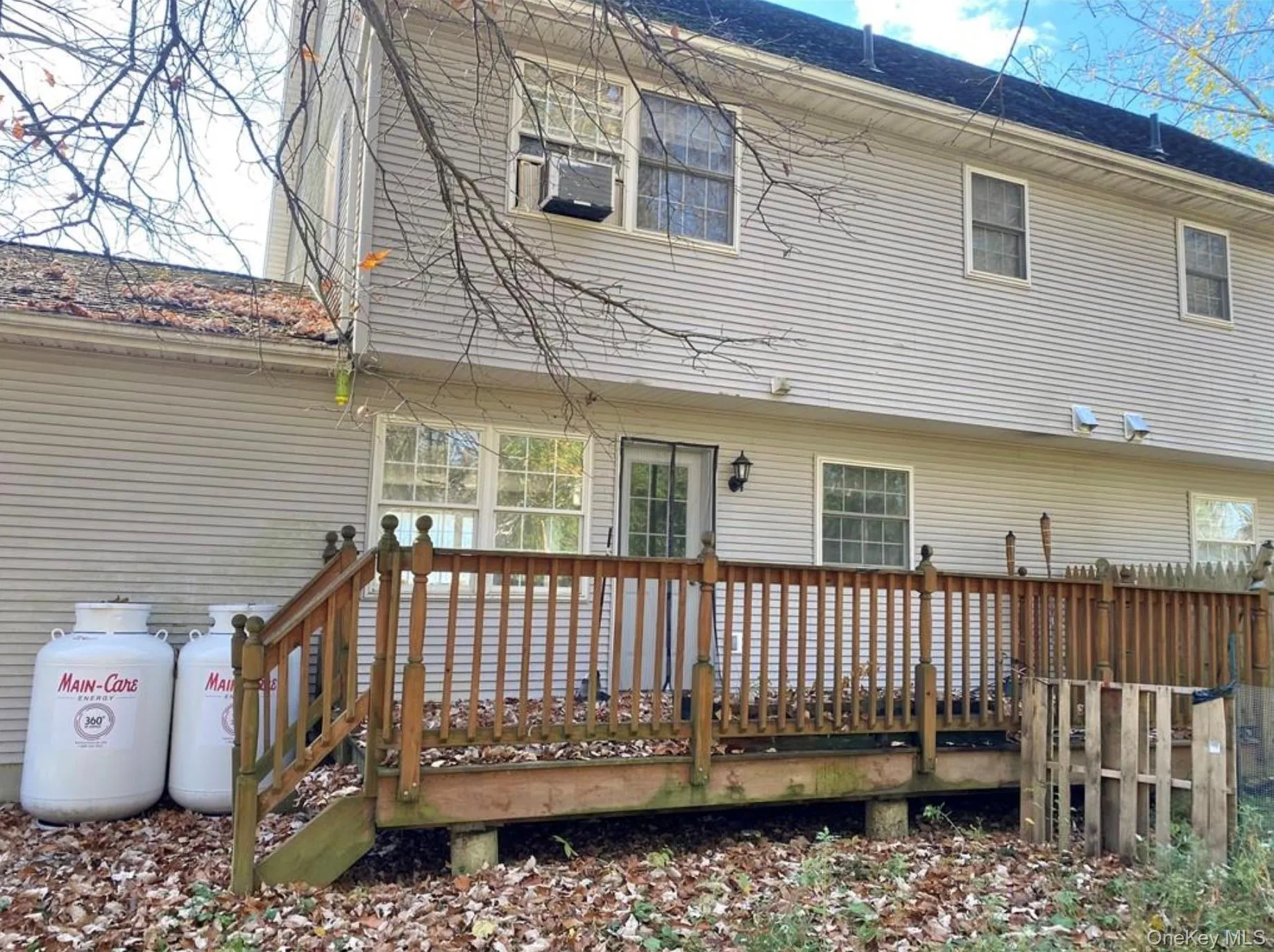 Rear view of property with a wooden deck and a shingled roof Rear view of property with a wooden deck and a shingled roof