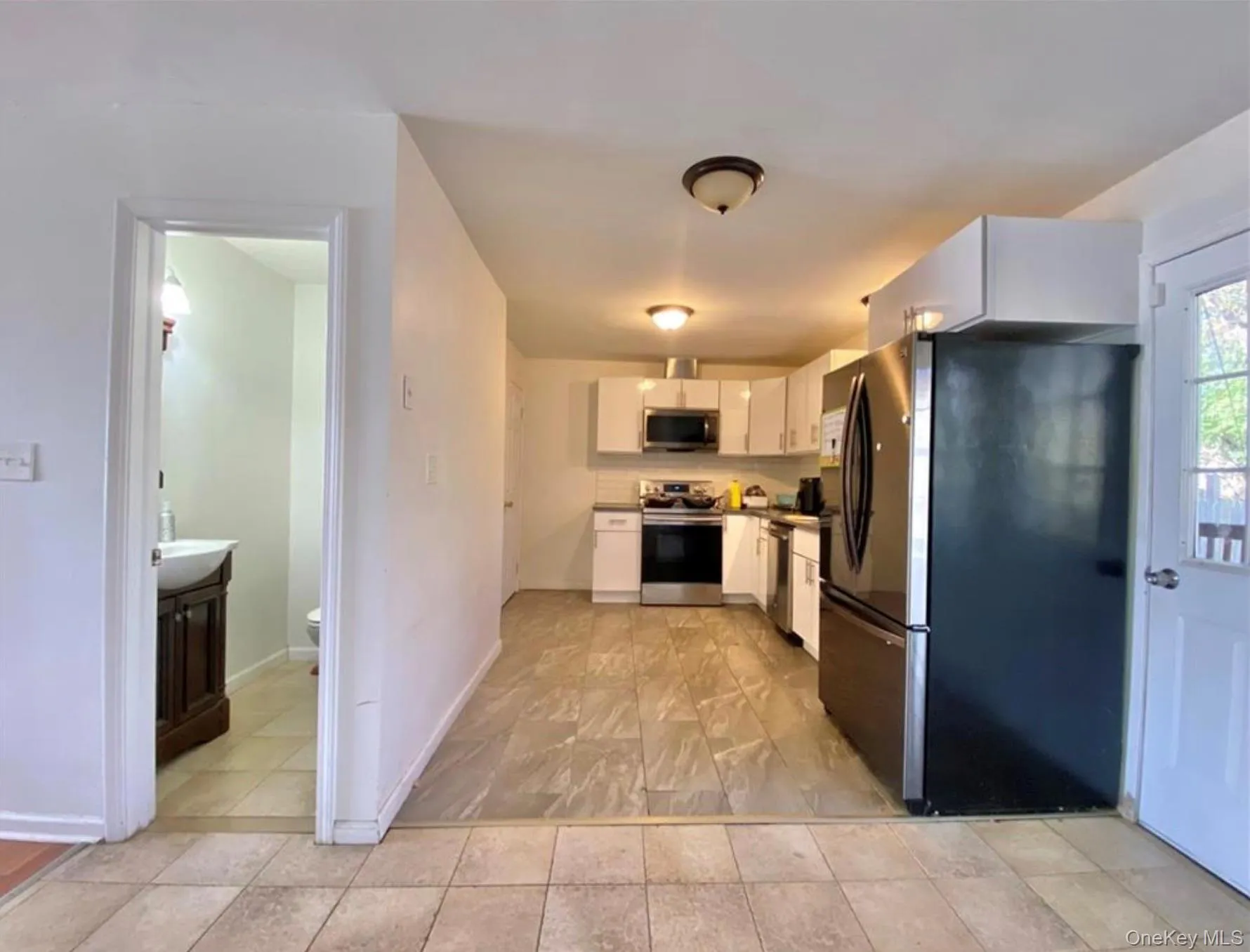Kitchen with appliances with stainless steel finishes and white cabinetry Kitchen with appliances with stainless steel finishes and white cabinetry