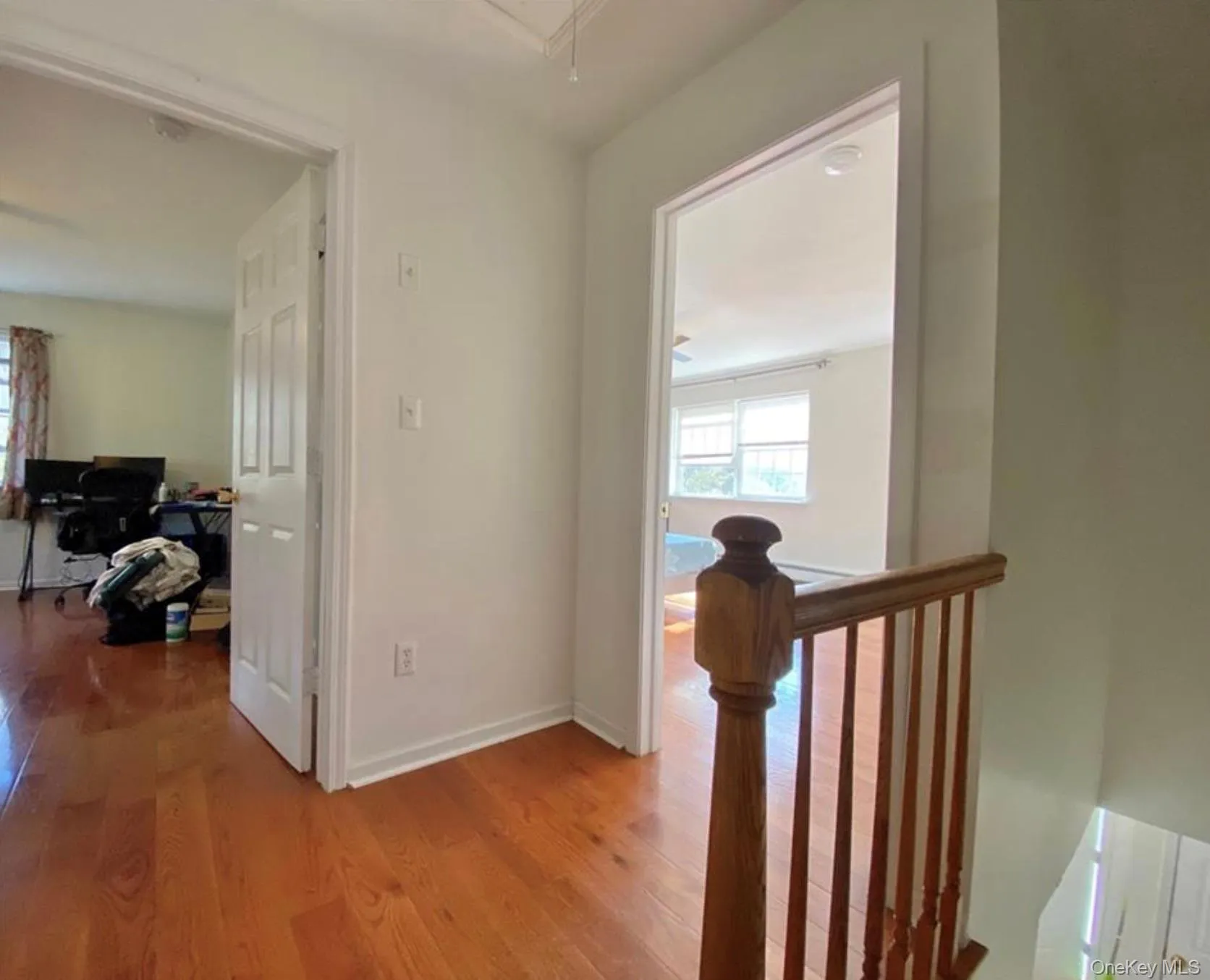 Hallway with a desk, light wood finished floors, attic access, and an upstairs landing Hallway with a desk, light wood finished floors, attic access, and an upstairs landing