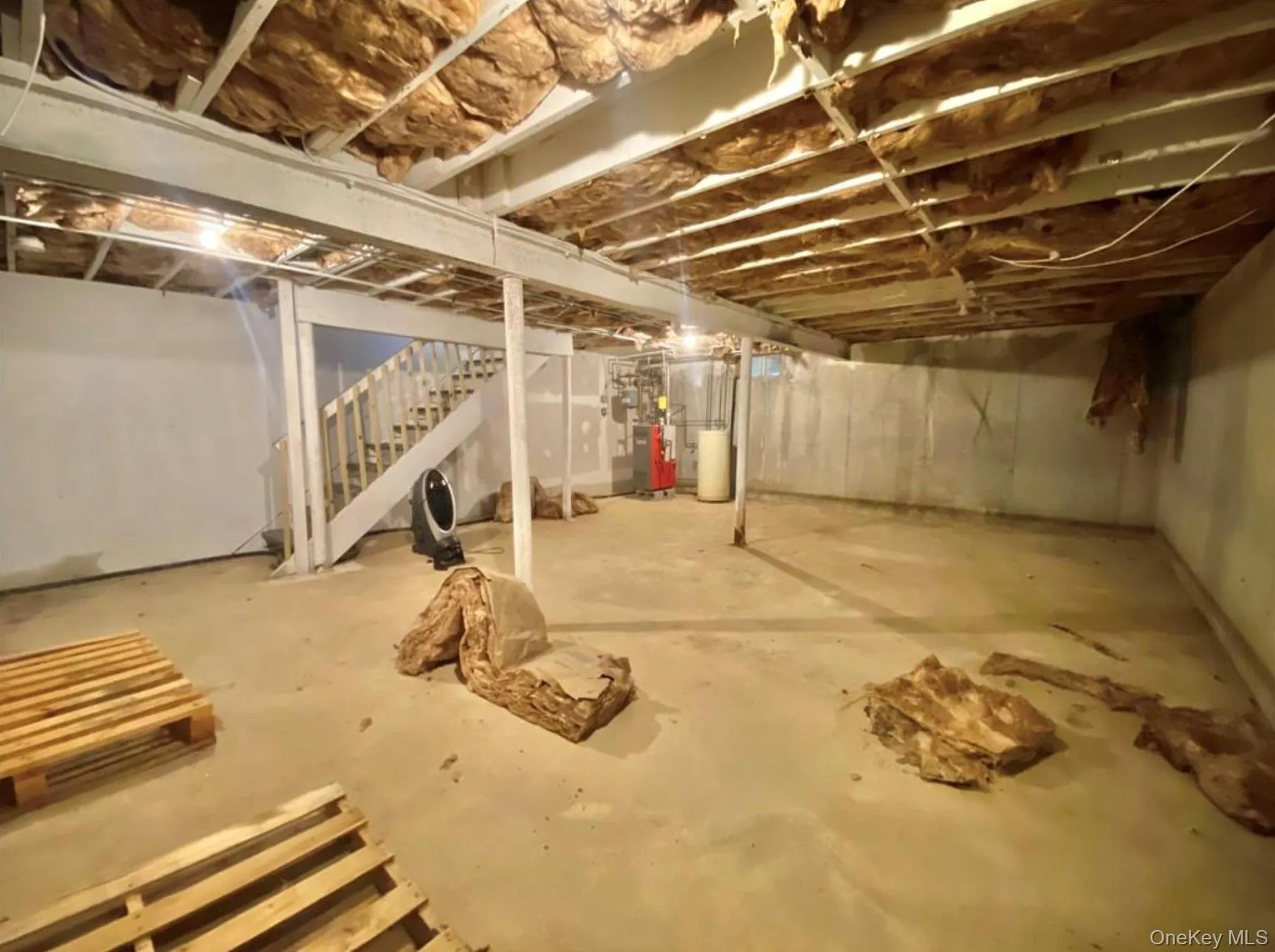 Unfinished below grade area with stairway and water heater Unfinished below grade area with stairway and water heater