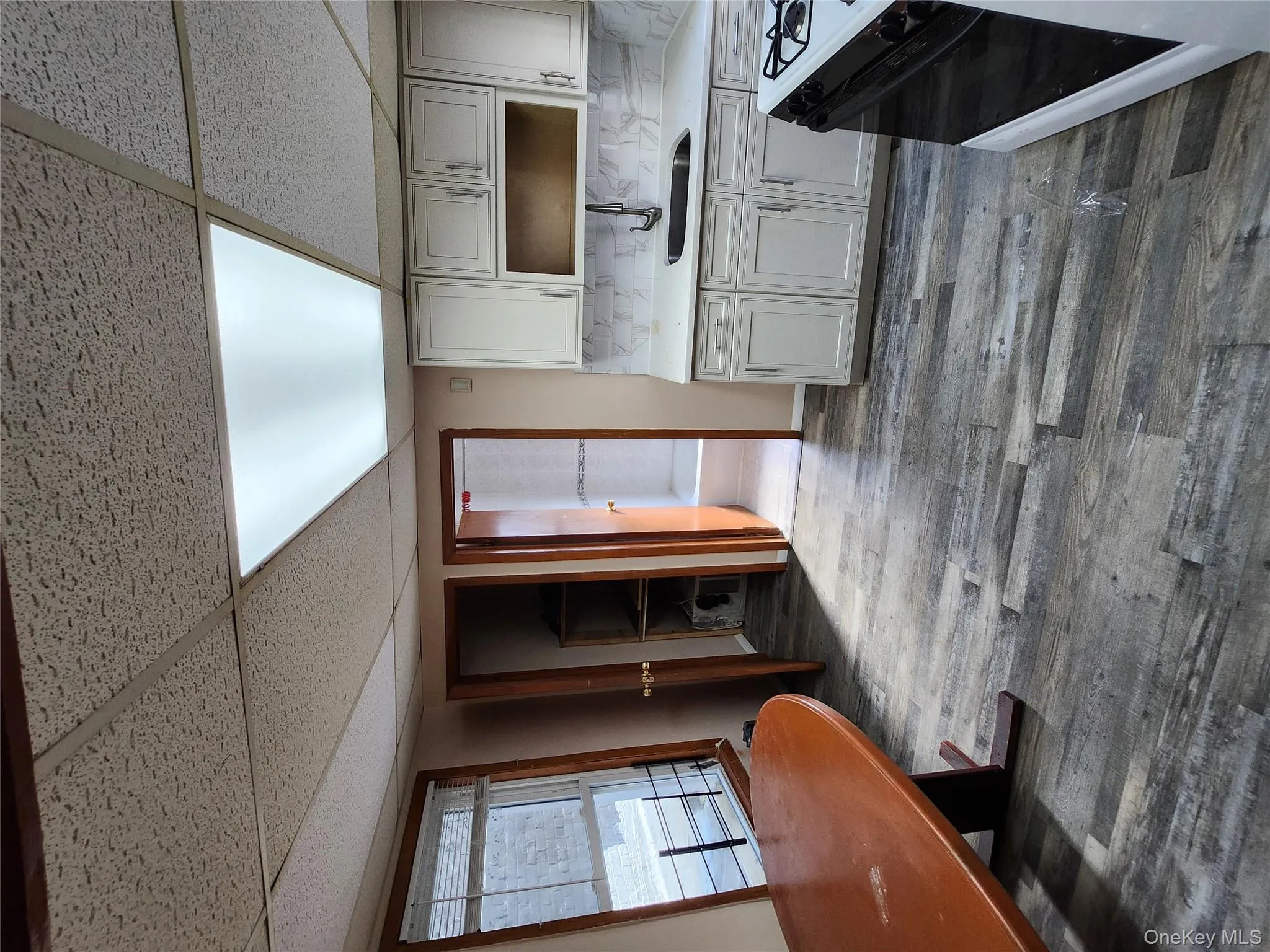 Kitchen with stove, a drop ceiling, decorative backsplash, and dark wood-style flooring Kitchen with stove, a drop ceiling, decorative backsplash, and dark wood-style flooring