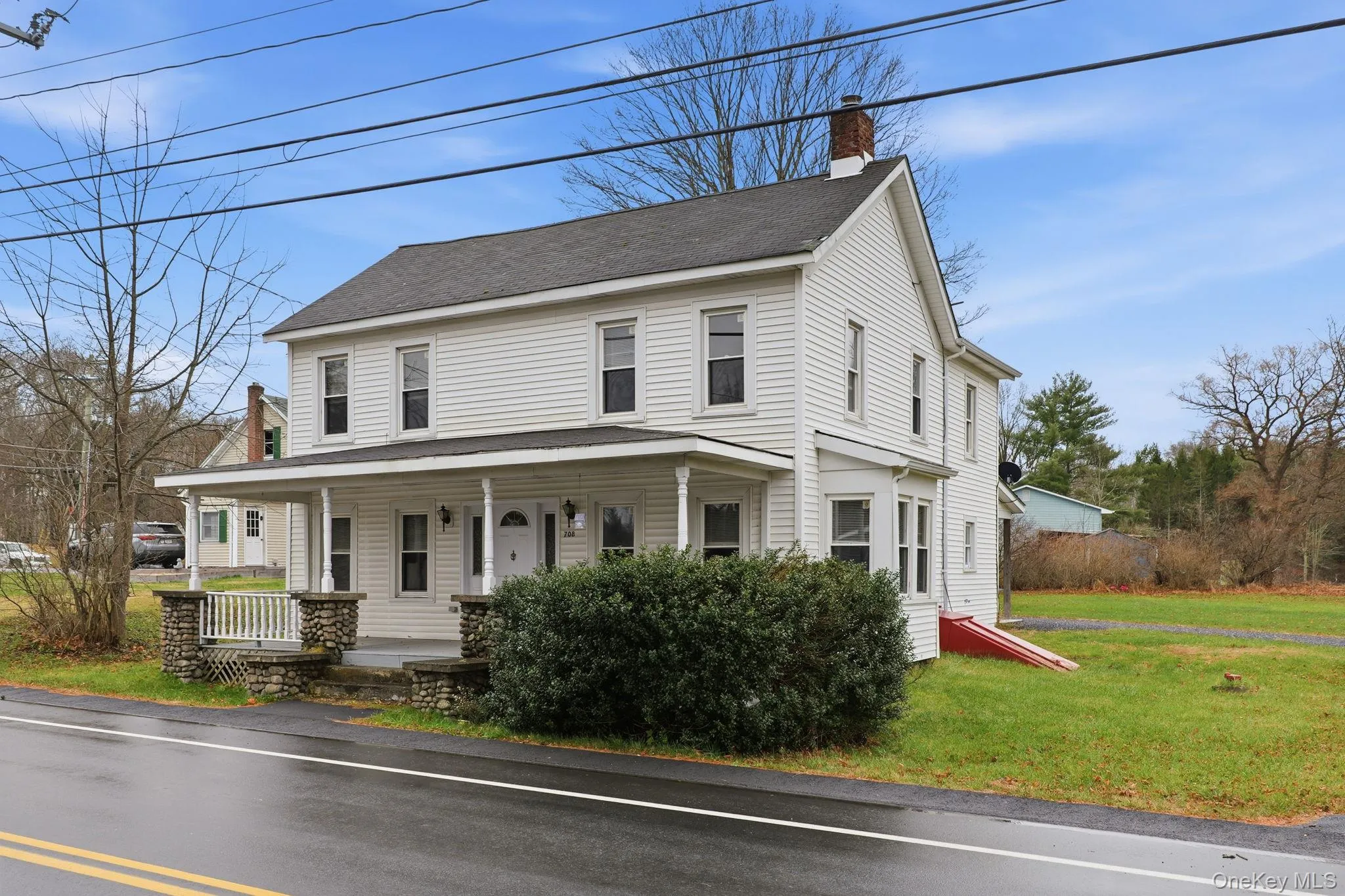 View of front of house with a porch, a front lawn, a chimney, and roof with shingles View of front of house with a porch, a front lawn, a chimney, and roof with shingles