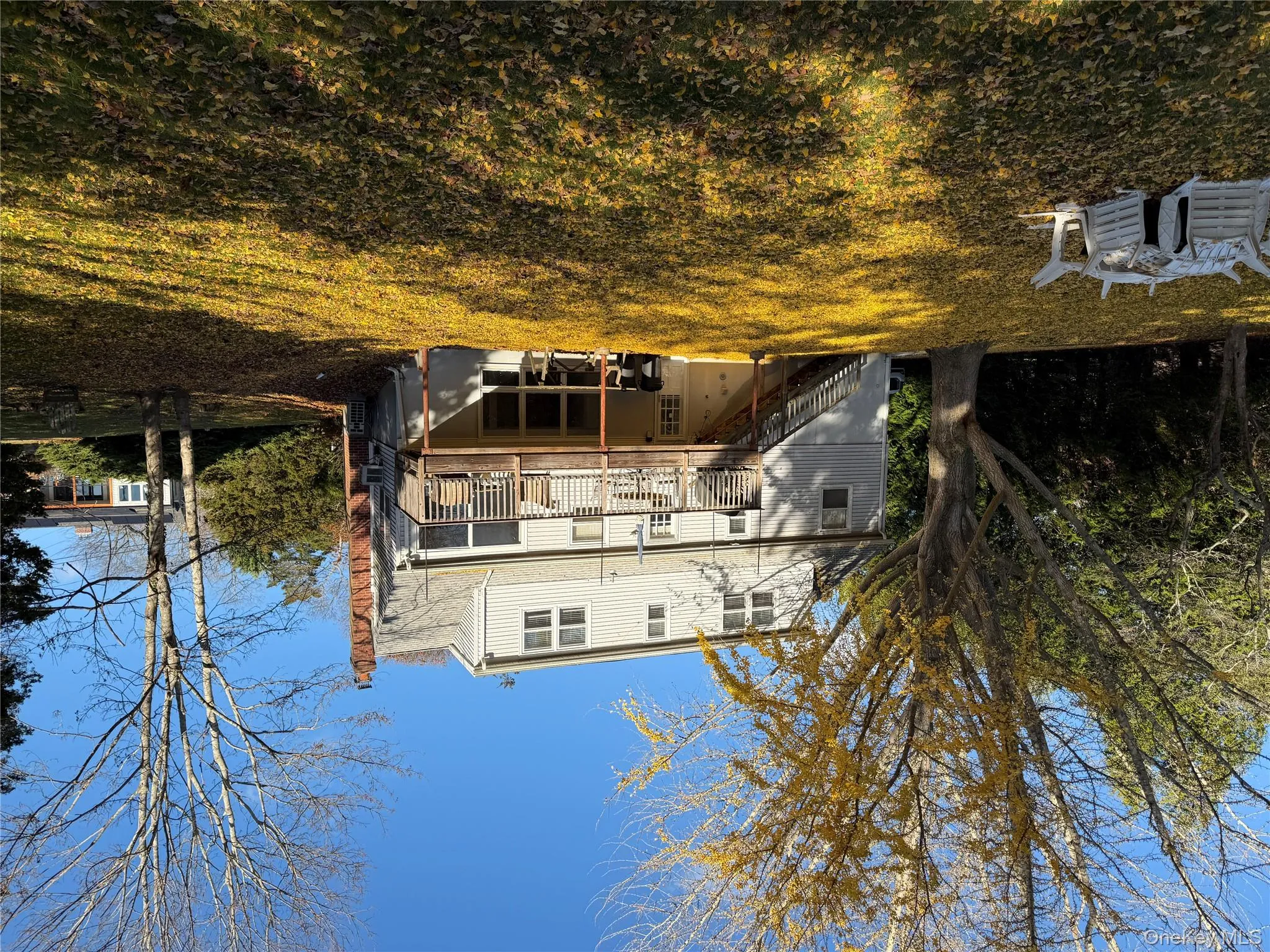 Rear view of house featuring stairs, a chimney, a deck, and a yard Rear view of house featuring stairs, a chimney, a deck, and a yard