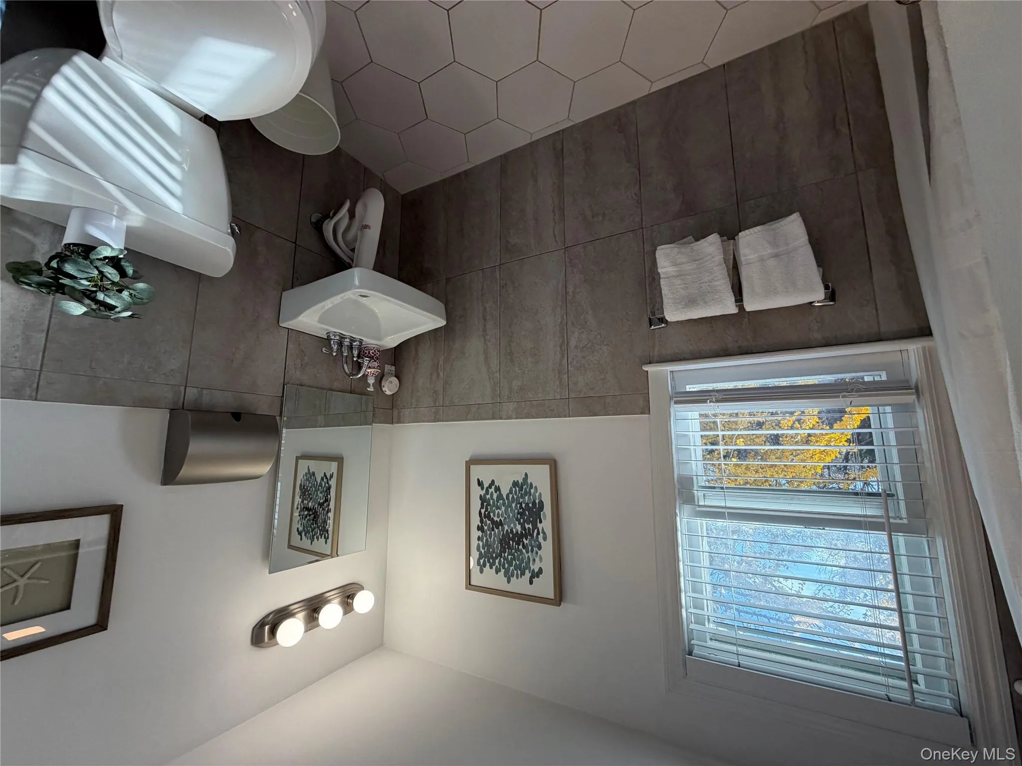 Bathroom featuring a wainscoted wall, tile walls, and tile patterned flooring Bathroom featuring a wainscoted wall, tile walls, and tile patterned flooring