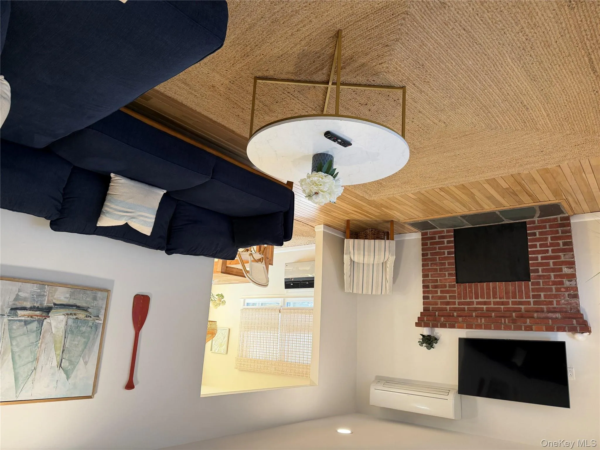 Living room with a fireplace, wood finished floors, a wall unit AC, and recessed lighting Living room with a fireplace, wood finished floors, a wall unit AC, and recessed lighting