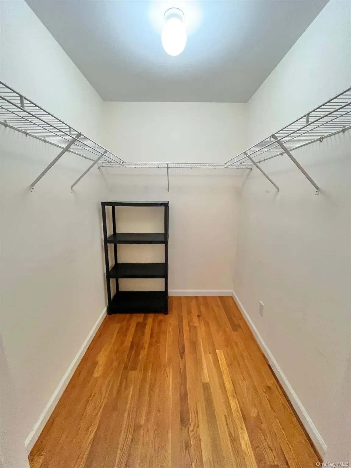 Walk in closet with light wood-type flooring Walk in closet with light wood-type flooring