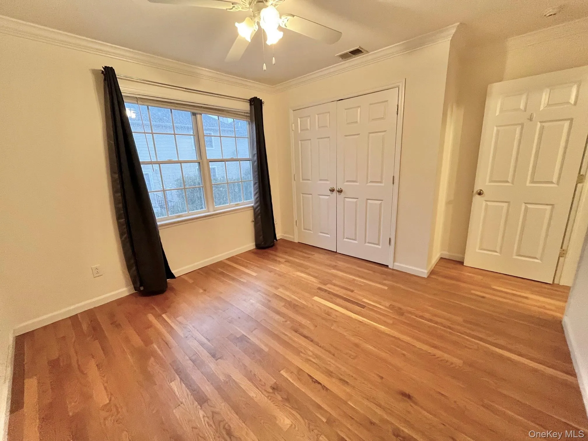 Unfurnished bedroom featuring crown molding, light wood-type flooring, ceiling fan, and a closet Unfurnished bedroom featuring crown molding, light wood-type flooring, ceiling fan, and a closet