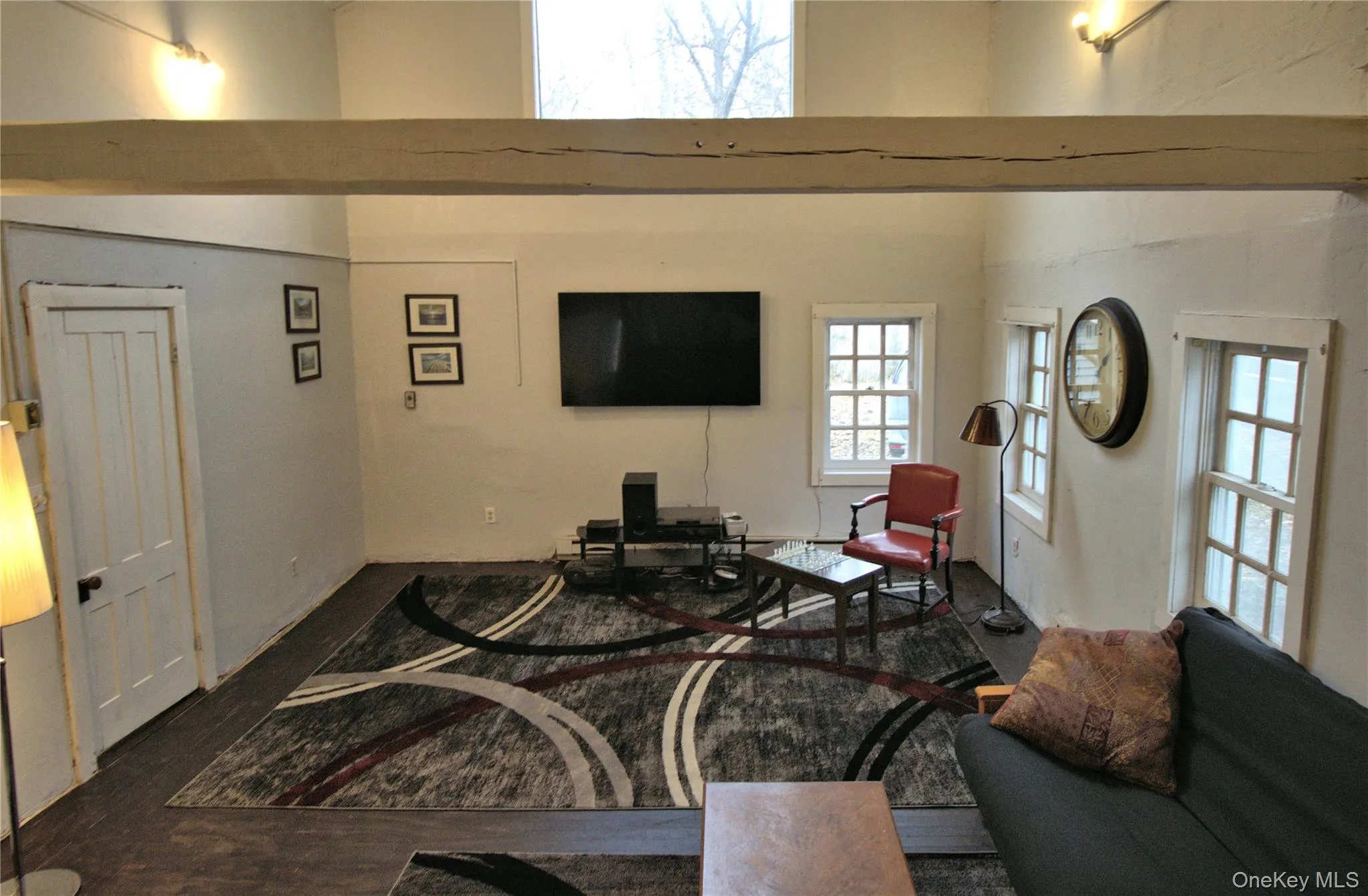 Living area featuring wood finished floors and a high ceiling Living area featuring wood finished floors and a high ceiling