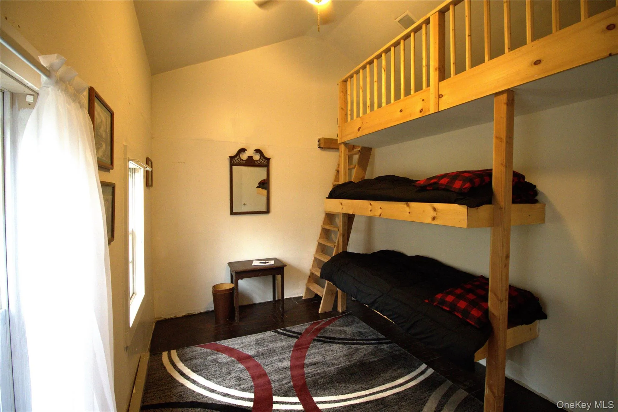Bedroom with vaulted ceiling and wood finished floors Bedroom with vaulted ceiling and wood finished floors