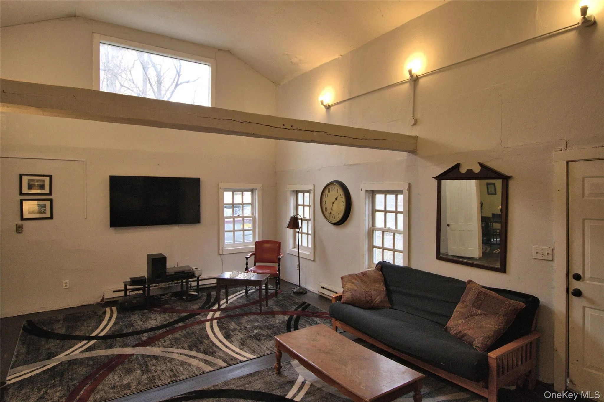 Living room featuring high vaulted ceiling and baseboard heating Living room featuring high vaulted ceiling and baseboard heating