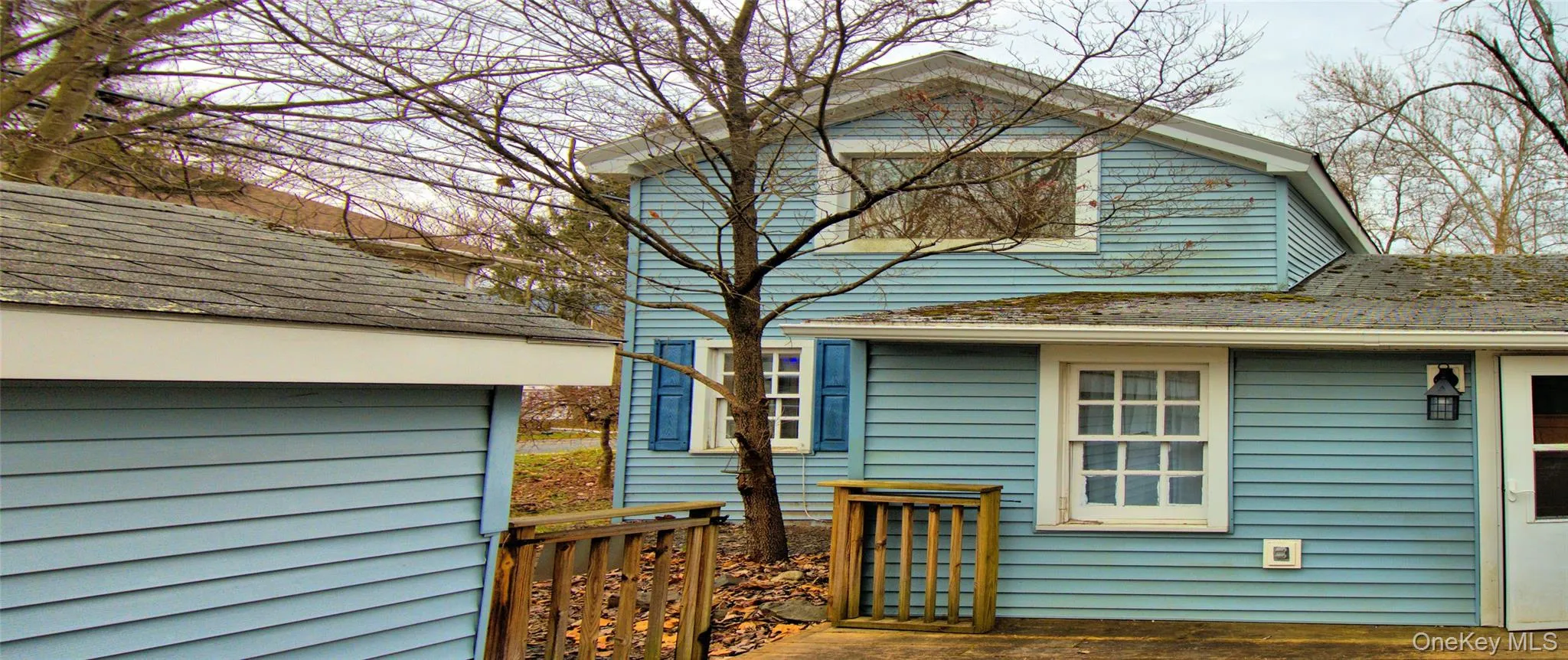 Back of property featuring a shingled roof Back of property featuring a shingled roof