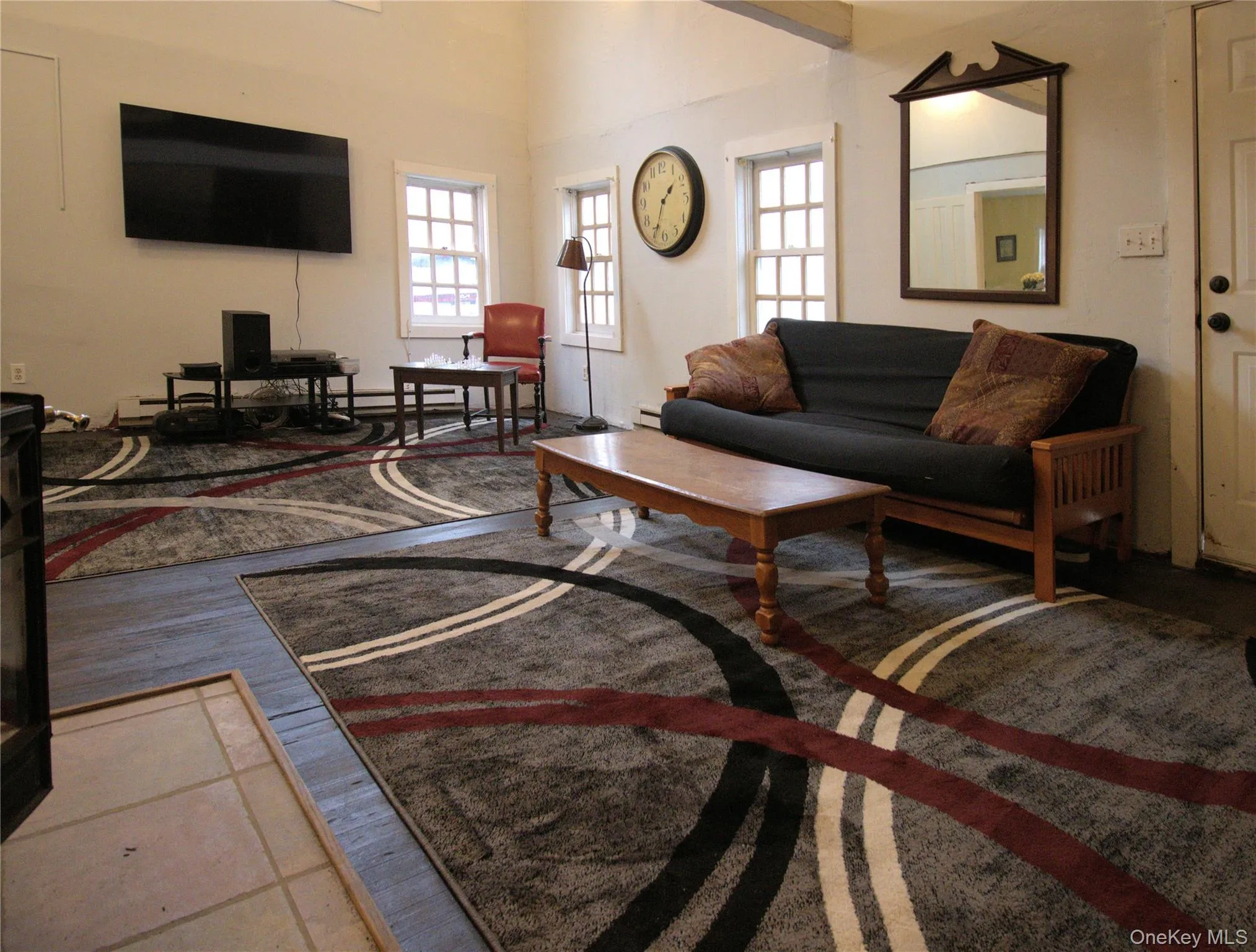 Living area with plenty of natural light, a towering ceiling, and light wood finished floors Living area with plenty of natural light, a towering ceiling, and light wood finished floors