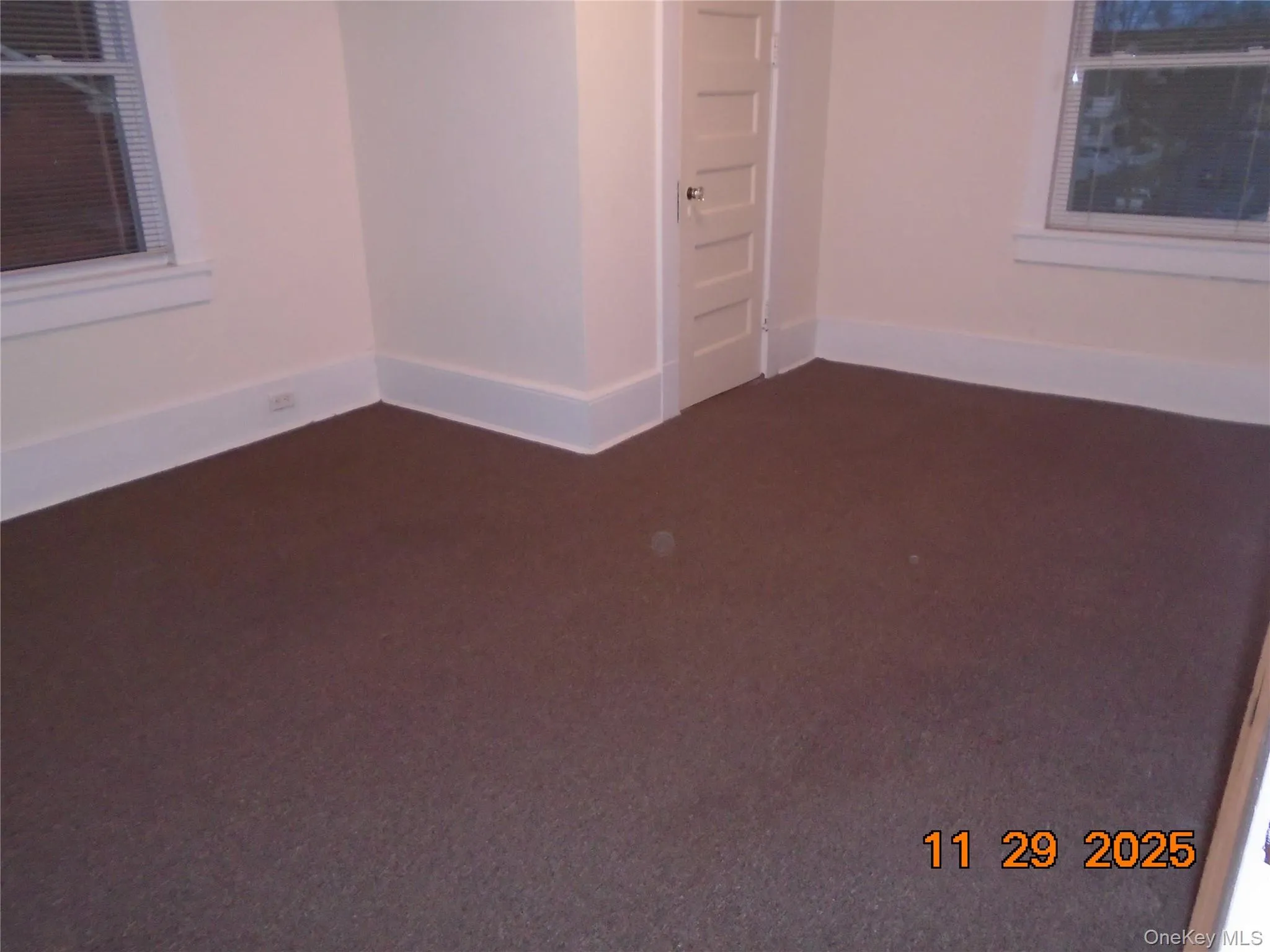 Spare room featuring dark colored carpet and baseboards Spare room featuring dark colored carpet and baseboards