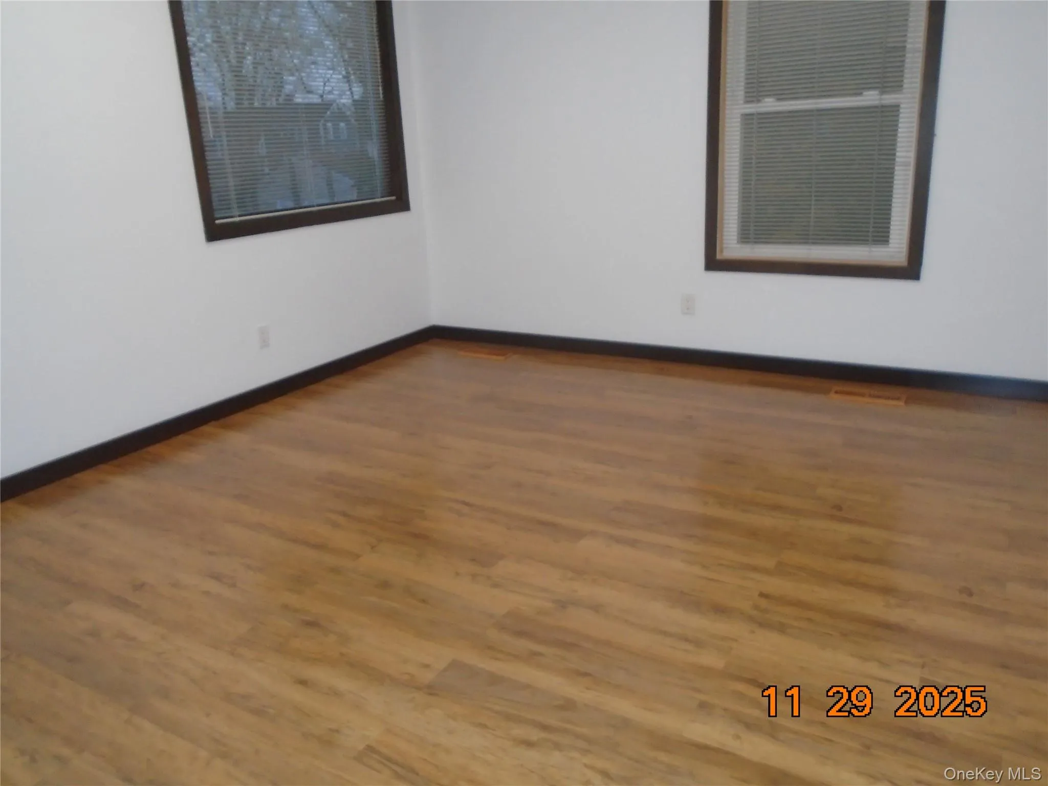 Spare room featuring wood finished floors and baseboards Spare room featuring wood finished floors and baseboards