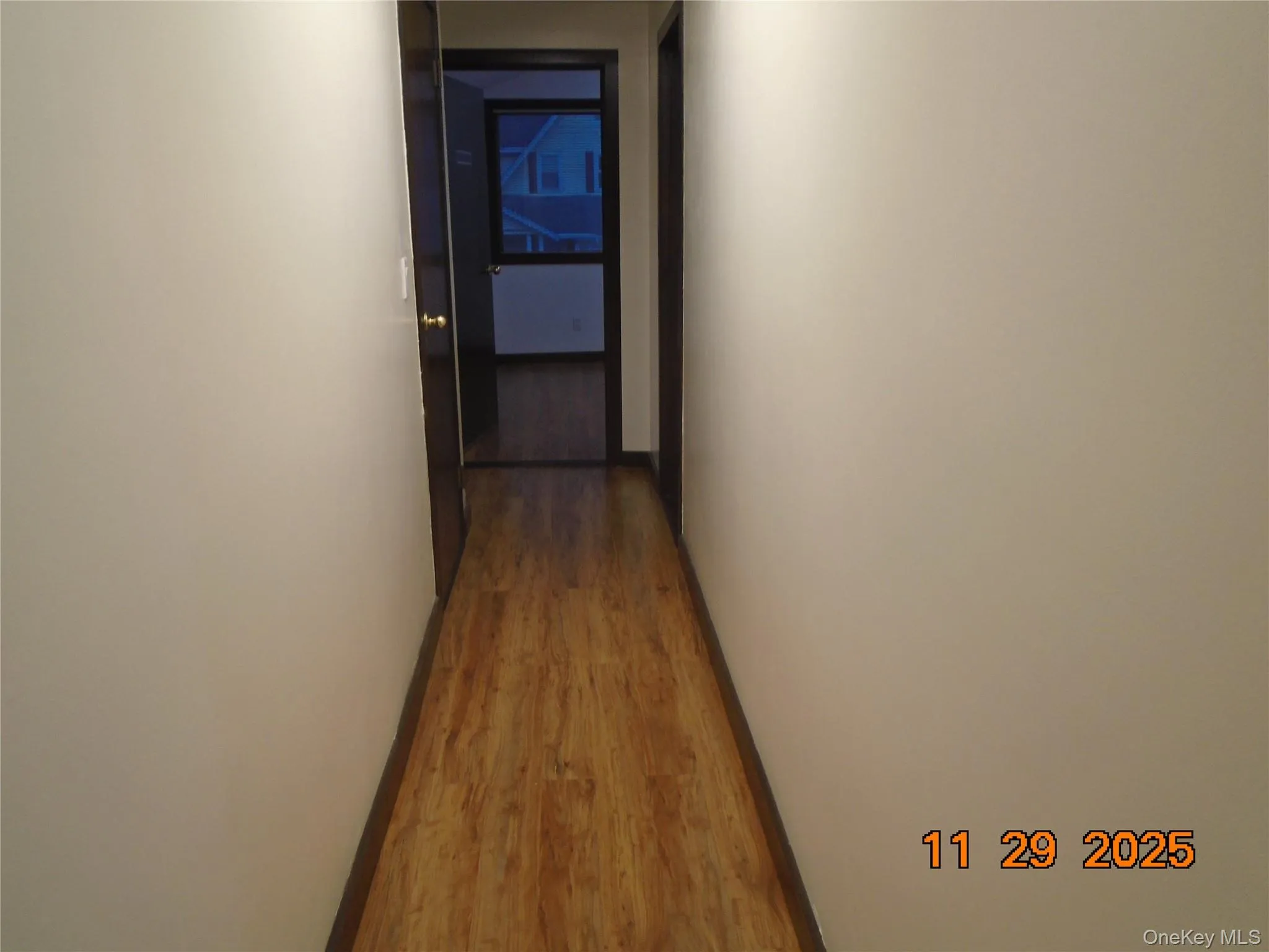 Hall with baseboards and wood finished floors Hall with baseboards and wood finished floors