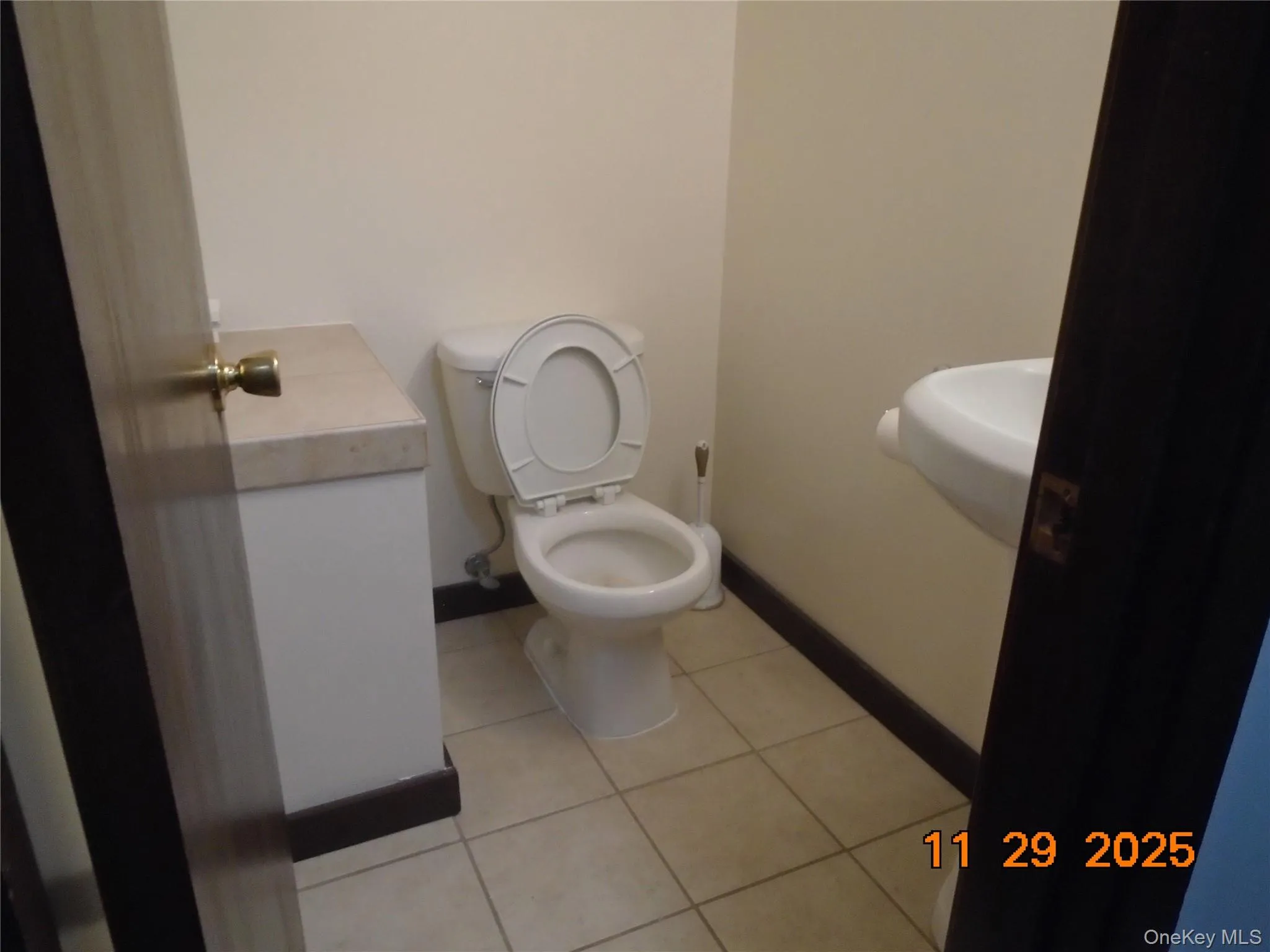 Half bath featuring light tile patterned floors and vanity Half bath featuring light tile patterned floors and vanity