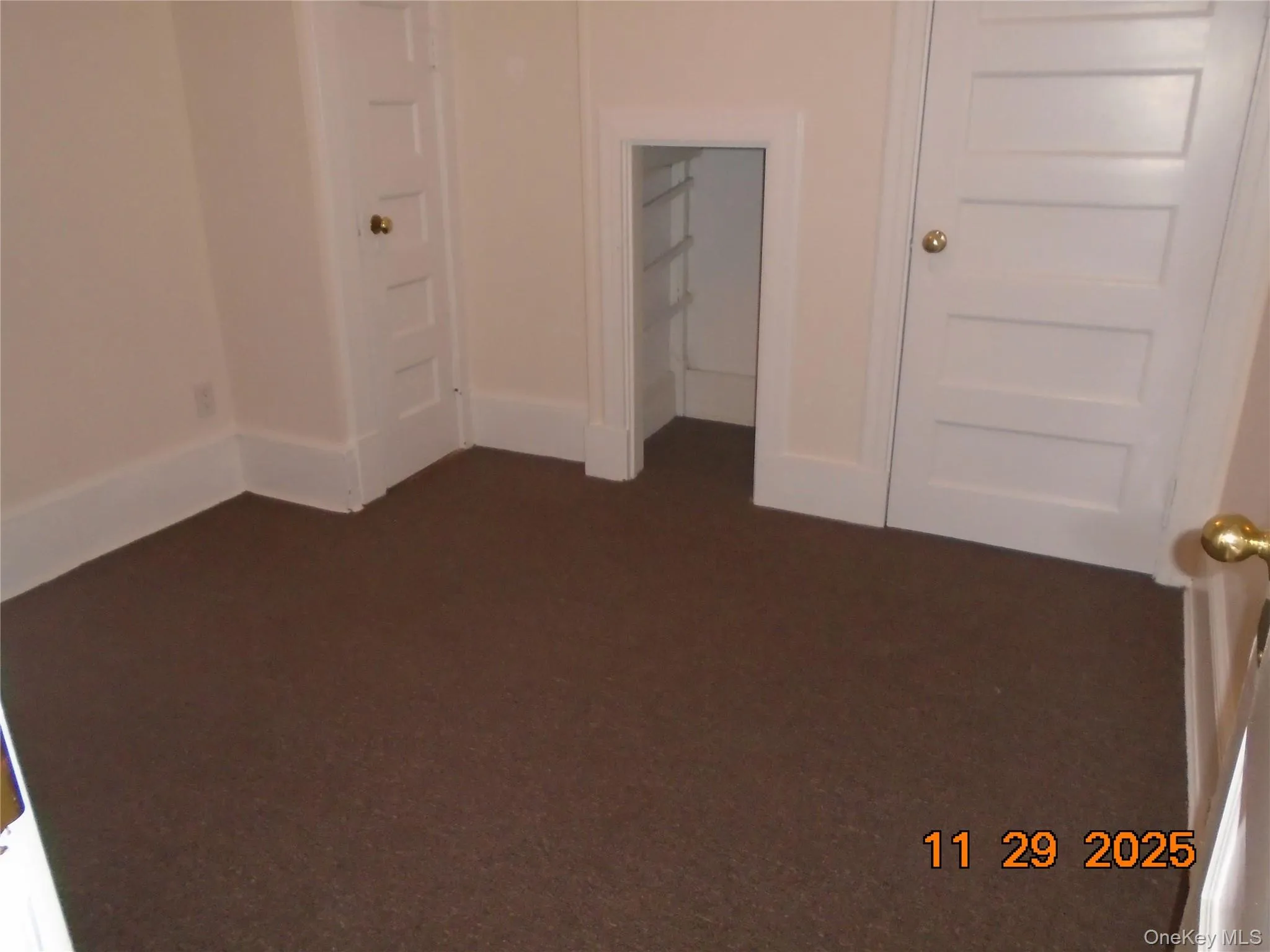 Unfurnished room with dark colored carpet and baseboards Unfurnished room with dark colored carpet and baseboards