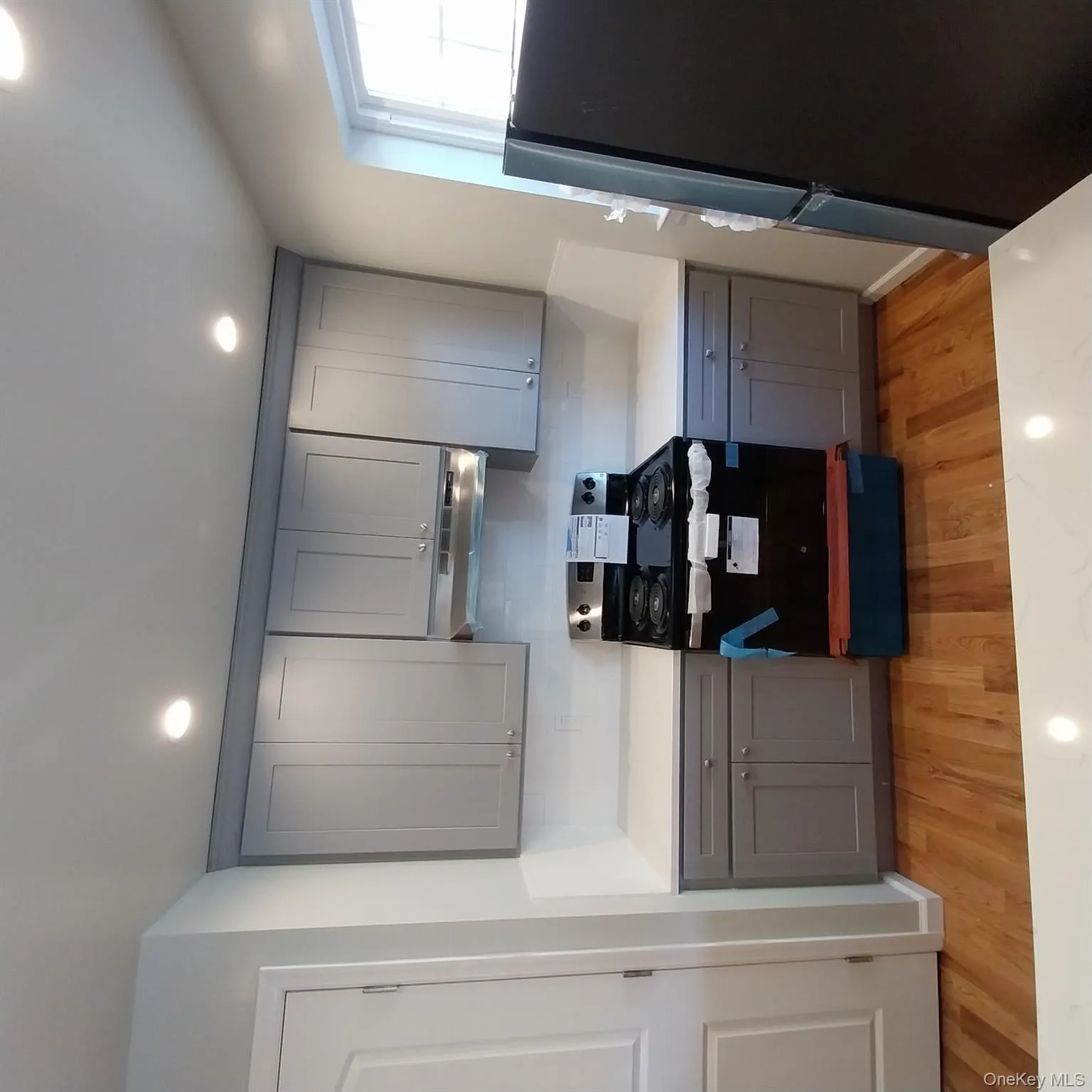 Kitchen featuring gray cabinetry, stainless steel range, fridge, light wood-style floors, and recessed lighting Kitchen featuring gray cabinetry, stainless steel range, fridge, light wood-style floors, and recessed lighting