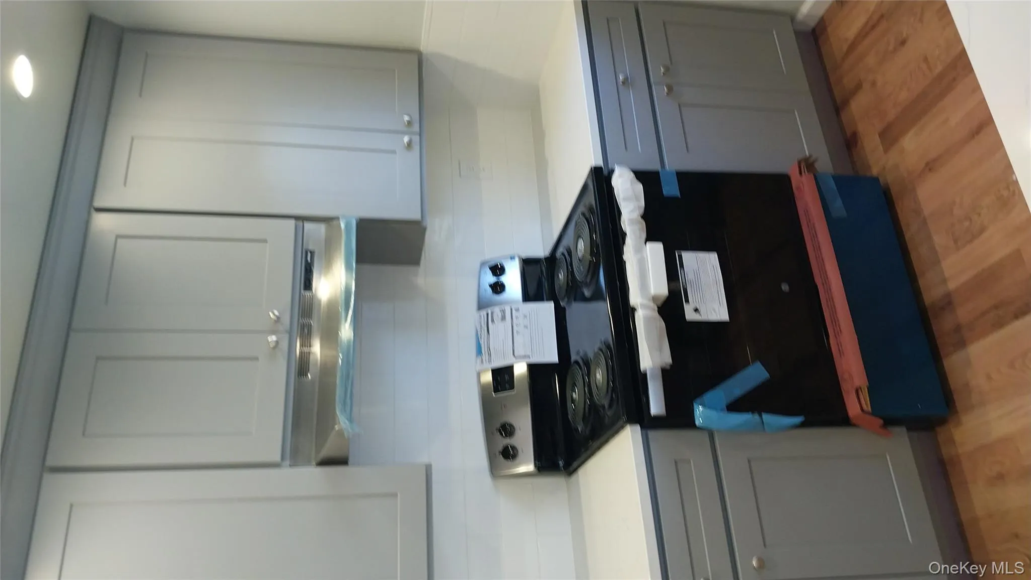 Kitchen with stainless steel electric stove, gray cabinets, and decorative backsplash Kitchen with stainless steel electric stove, gray cabinets, and decorative backsplash