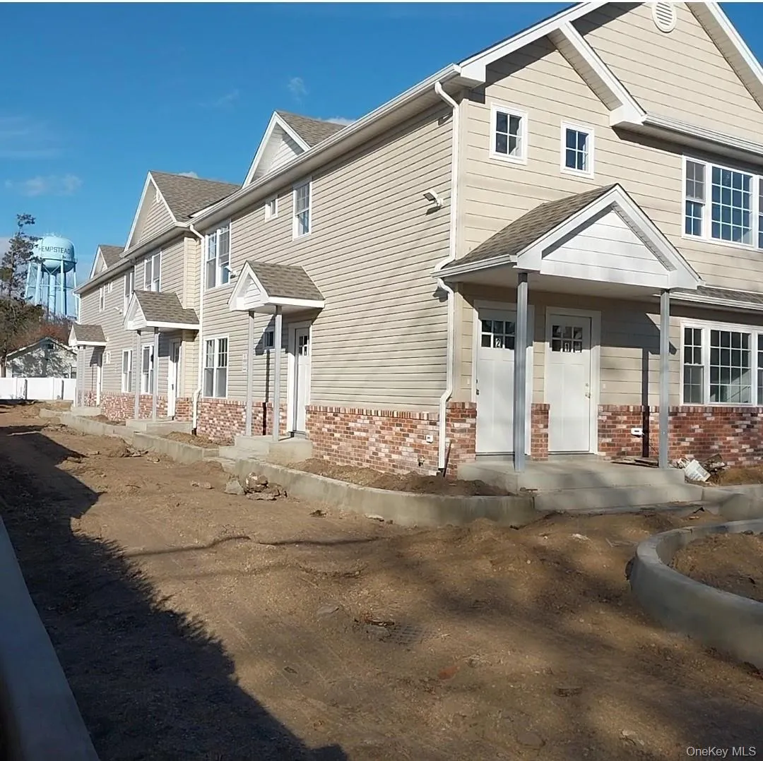View of front of property with brick siding and a shingled roof View of front of property with brick siding and a shingled roof