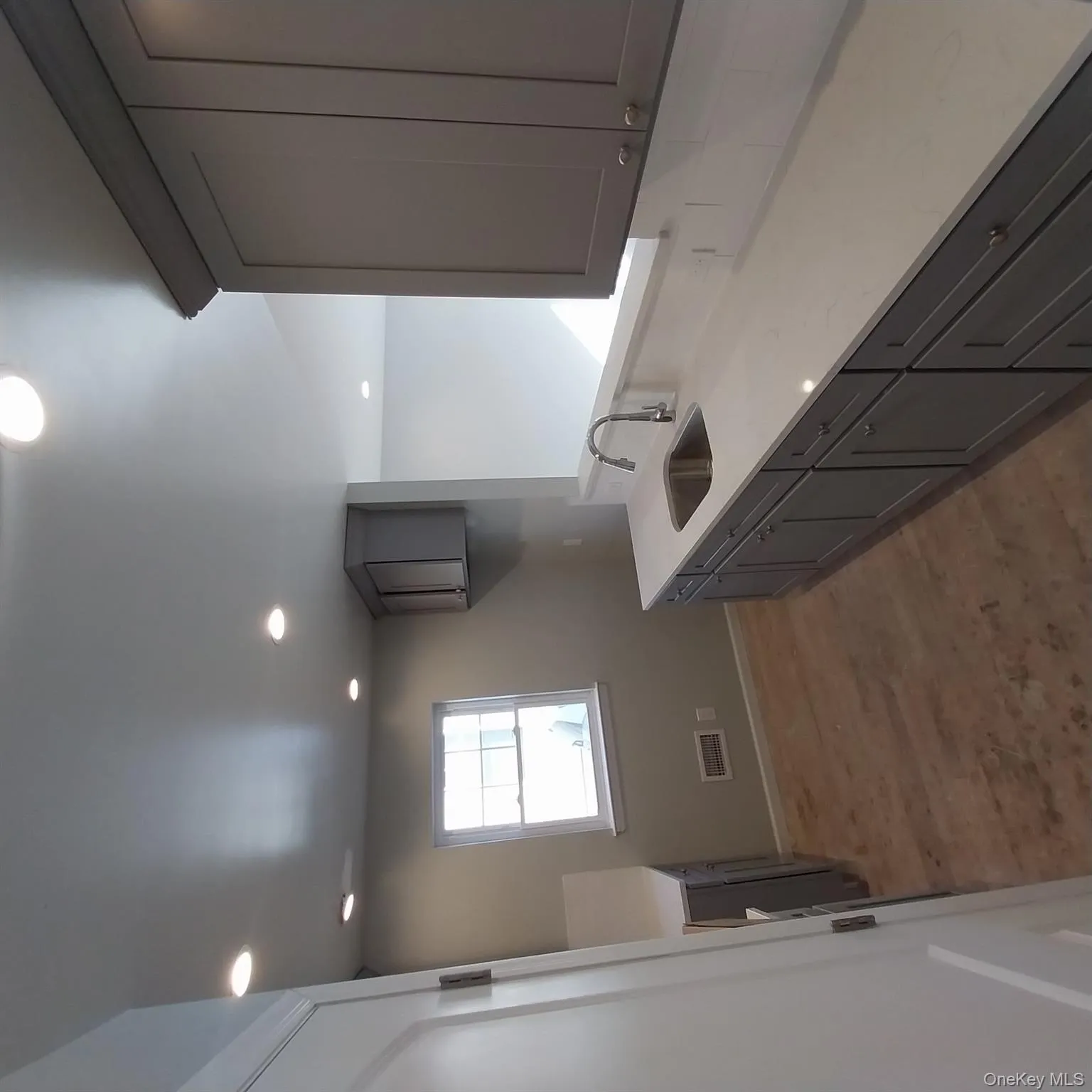 Kitchen with light stone counters, gray cabinetry, light wood-style flooring, and recessed lighting Kitchen with light stone counters, gray cabinetry, light wood-style flooring, and recessed lighting