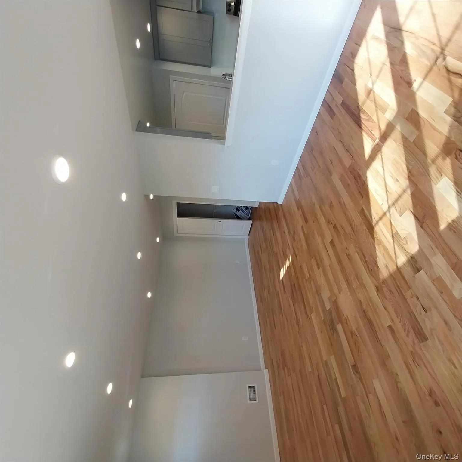Unfurnished living room with light wood-type flooring and recessed lighting Unfurnished living room with light wood-type flooring and recessed lighting