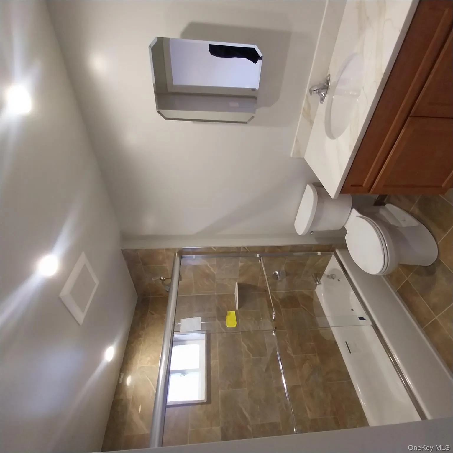Bathroom with combined bath / shower with glass door, dark tile patterned floors, vanity, and recessed lighting Bathroom with combined bath / shower with glass door, dark tile patterned floors, vanity, and recessed lighting