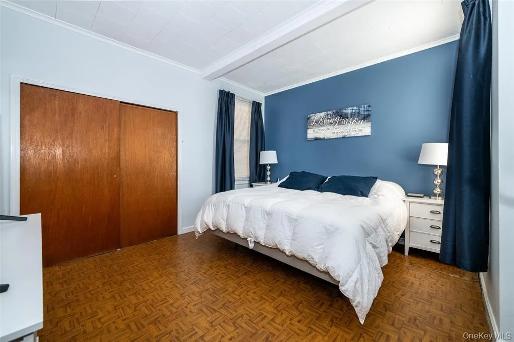 Bedroom featuring crown molding, a closet, and beamed ceiling Bedroom featuring crown molding, a closet, and beamed ceiling
